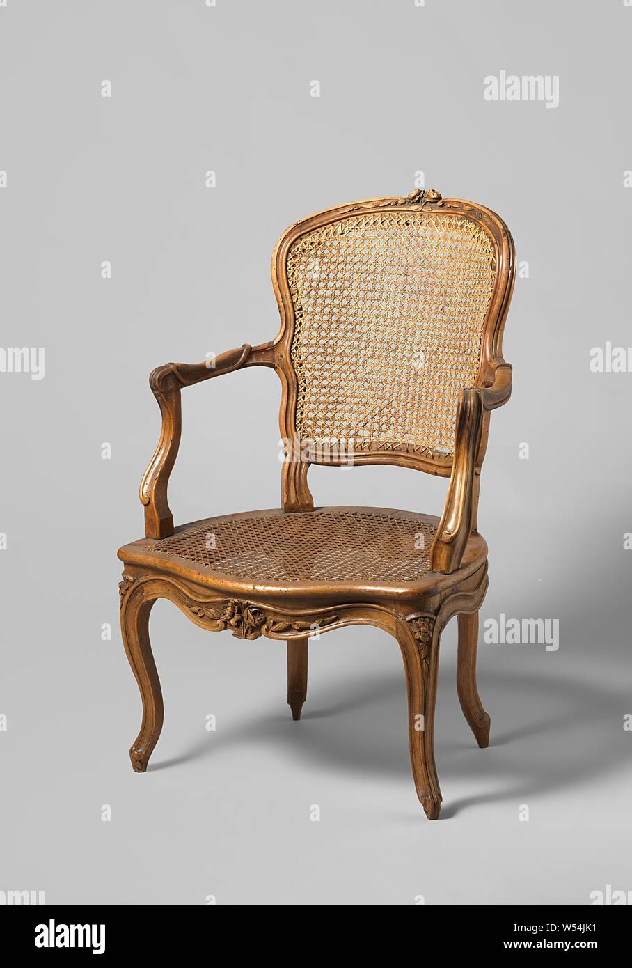 Sessel aus Nussbaum mit S-förmigen abgewinkelten Beinen mit dem Schnitzen von Blüten und Blättern. Rückenlehne und Sitzfläche aus gewebtem Wicker. Mit losen Kissen, Sessel aus Nussbaum (Möbel) mit Rückenlehne und Sitzfläche aus gewebtem Wicker. Die erweiterte S-förmigen abgewinkelten Beinen mit Profilierung in den Sitz Rahmen ohne Unterbrechung zusammenführen und sind mit Blumen geschmückt. Überbackene Stuhl mit Blume und Blatt. Armlehne struts positioniert nach hinten, S-förmige, hohlen Armlehnen endet in voluten. Obere Zeile Fenster mit skalierten Voluten. Mit losen Kissen., anonym, Frankreich, 1750 - 1775, Holz (Pflanzenmaterial Stockfoto