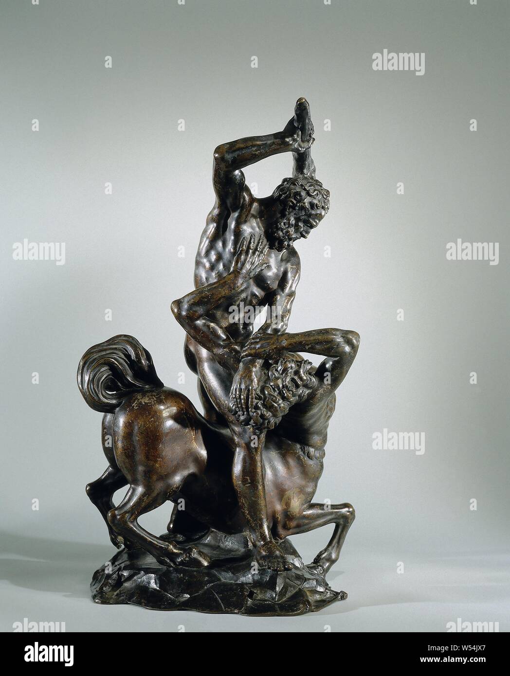 Hercules Slaying der Kentaur Eurytion Hercules Beats der Kentaur Eurytion, die bärtigen Hercules steht auf einem felsigen Boden rittlings auf den abgestürzten Eurytion, die er greift mit der linken Hand am Kopf drehte sich von ihm weg, während der erhobenen Rechten Club. Die eurytion, senkte die Vorderläufe, und mit seinem Kopf und Oberkörper seitlich abzulenken, versucht seinen Kopf von Hercules' griff mit einer Hand zu lösen und hat die anderen gegen seine Brust platziert. Seine bärtigen Gesicht verlassen hat, den Mund öffnete, Herkules und Deianira mit den sterbenden Nessus (Variante), Nessus, Giambologna (nach), Florenz (gegebenenfalls) Stockfoto