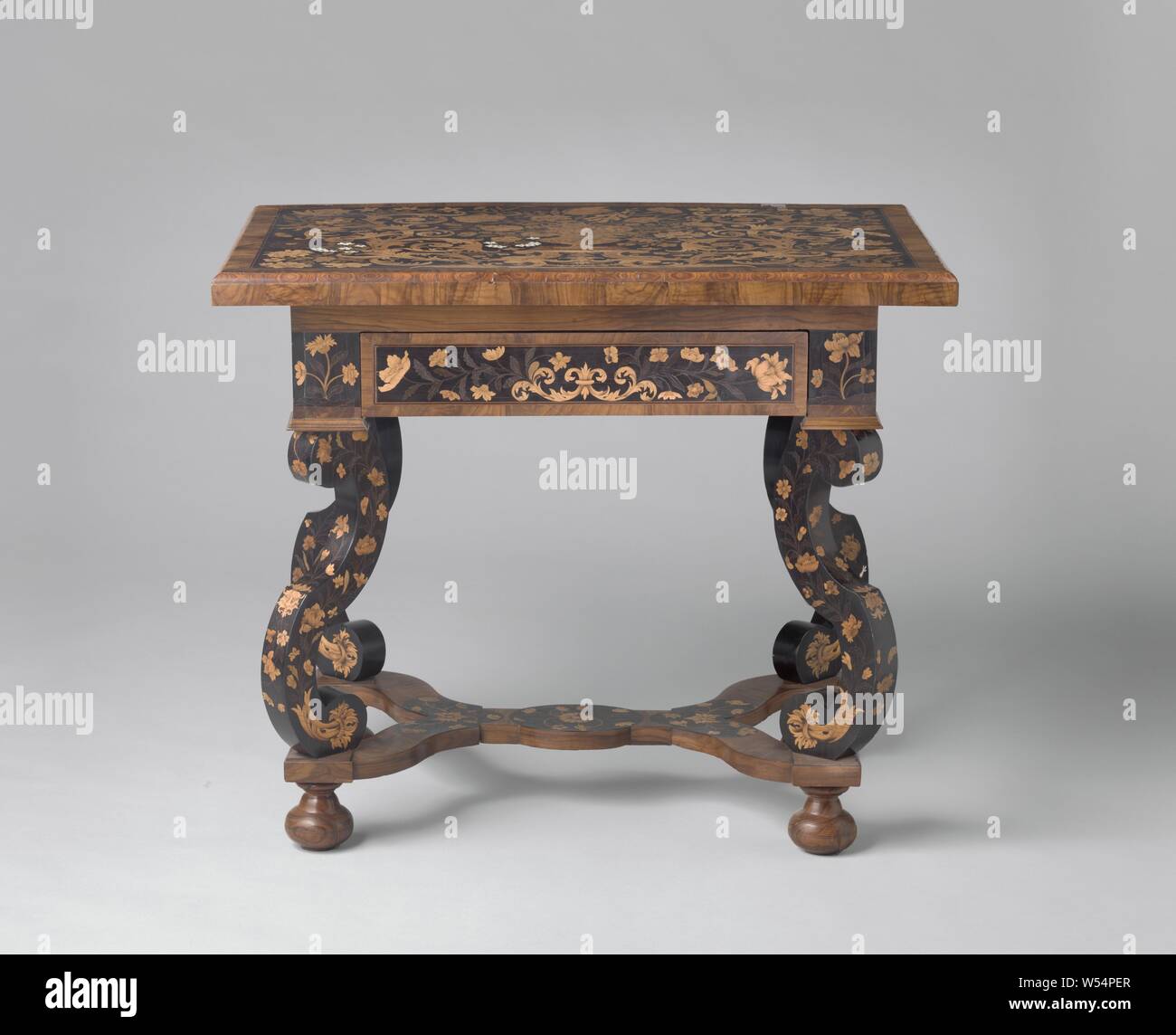 Tabelle, die vollständig mit floralen Motiven in verschiedenen Holzarten verklebt. S-förmige Beine, durch eine doppelte Y-förmigen Querschnitt, Tabelle vollständig mit floralen Motiven geklebt, aus Rosenholz, Satin, Olive, Amboina, Ahorn und anderen Holzarten und Knochen auf eine Eiche. Die Möbel ruht auf vier S-förmigen Beinen, die durch eine doppelte Y-förmigen Querschnitt zu einem ovalen Mittelteil, die auf die Kugel Beinen ruht. Die ecke Beiträge tragen einen profilierten Sockel. An der Vorderseite eine Schublade. Das Blatt zeigt eine Vase auf einem Sockel, ruht auf zwei wandte sich Delphine. Blatt und Blüte Reben stammen aus ihrem Mund., anonym Stockfoto