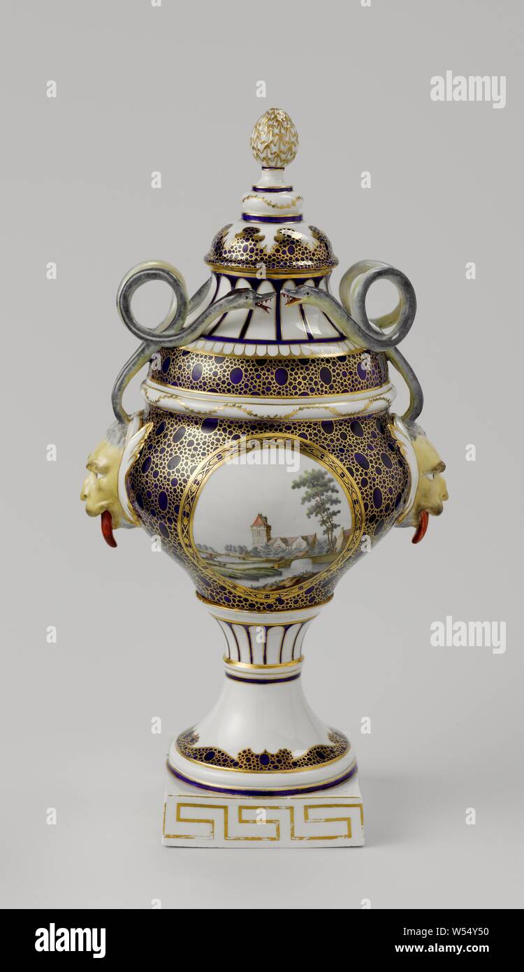 Lidded vase Vase mit Deckel Vase mit Deckel, mit Ohren in Form satyrkop mit gewelltem Schlangen, mit Blick auf Oudewater und mit Gebäuden in Wasser Landschaft gemalt, sowohl in einem Medaillon, sphärischen Vase mit Deckel auf einem quadratischen Sockel. Die Vase hat zwei Ohren in der Form eines Satyr Kopf mit zwei gewellten Schlangen aus den Kopf. Eine Seite ist mit einem Medaillon mit Blick auf Oudewater, auf der anderen Seite mit Gebäuden in einem Wasser Landschaft eingerichtet. Um es ein Blauer Fond mit caillouté" in Gold. Mit einem Storch in Blau auf die Glasur gekennzeichnet. Hinweis: Tournai weich Porzellan bemalt. in Den Haag, Den Haag Porseleinfabriek Stockfoto