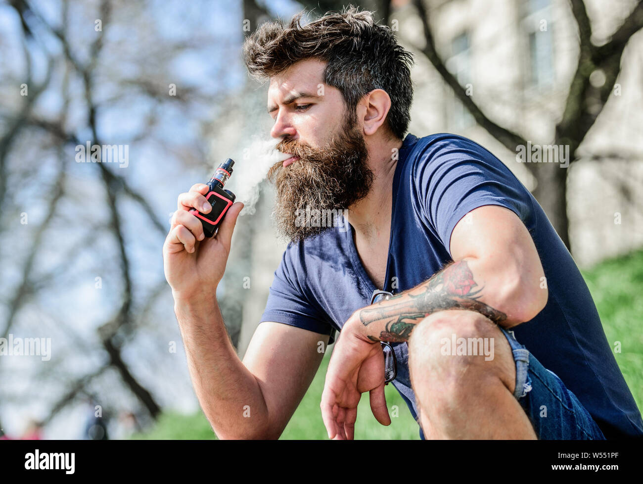 Bärtiger Mann rauchen vape. Rauchen elektronische Zigarette. Rauchen Gerät.  Man langen Bart entspannt mit Rauchen Gewohnheit. Mann mit Bart atmen Sie  rauchen. Wolken aromatisierte rauchen. Stress Relief Konzept  Stockfotografie