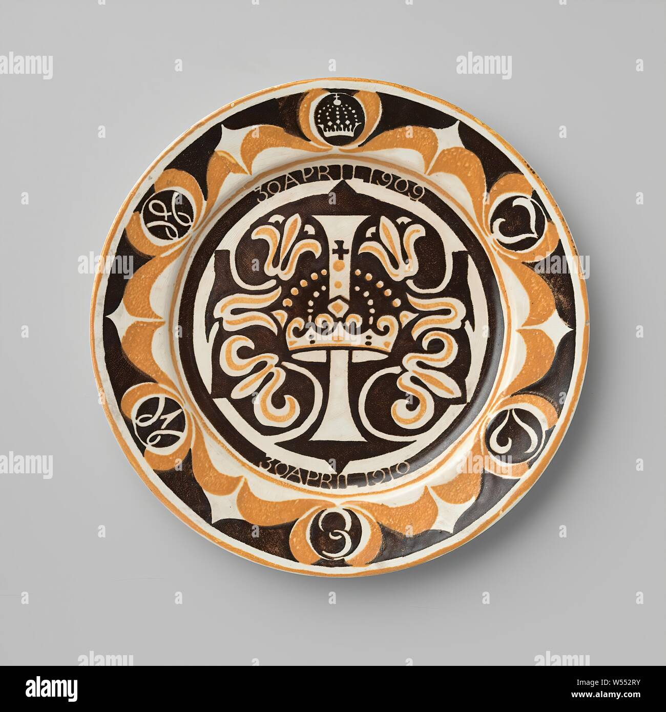 Gedenktafel für die 1-jährige Prinzessin Juliana, Memorial Platte aus Steingut, anlässlich des ersten Geburtstag der Prinzessin Juliana, mit einem gedruckten Einrichtung in Gelb und Mangan. In der Mitte der Buchstabe I, durch eine Krone, durch die Blume gnats umgeben, in einer Mangan gern gespeichert erstochen. Über dem ich am 30. April 1909, unter dem ich am 30. April 1910, in einem breiten Mangan Streifen gespeichert. Auf der Felge an der Spitze einer Krone, und dann im Uhrzeigersinn die Buchstaben J, L, E, M und W, in einem Mangan Medaillon in eine gelbe Blume Cup gesichert. Entlang der Kante, die ein gelbes Band. Hängende Löcher in den Fuß Ring., Carel Stockfoto