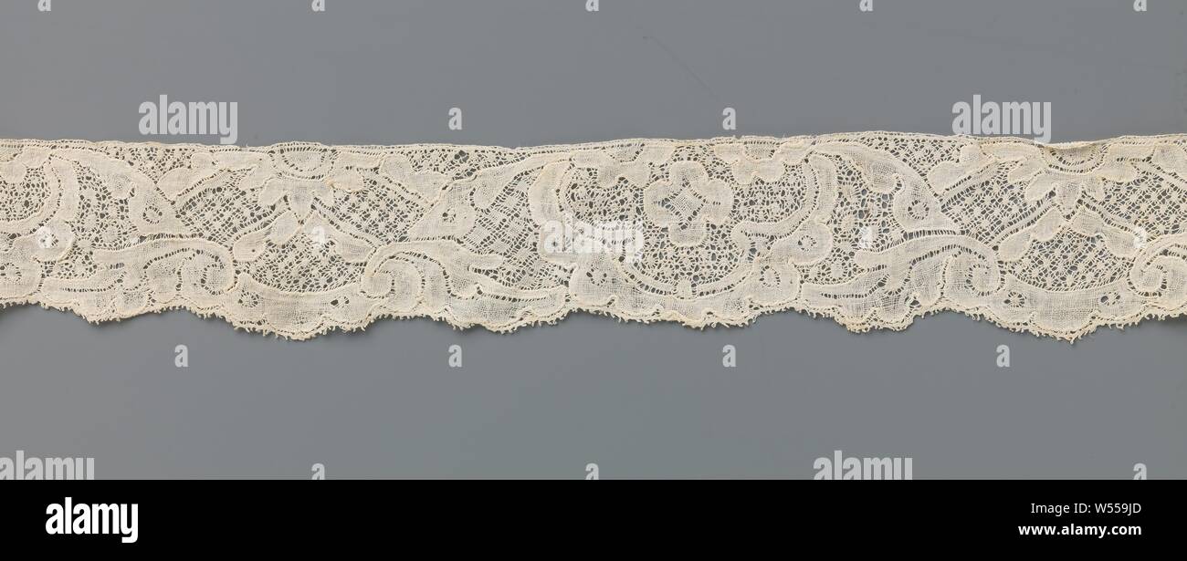 Streifen des Schiebers Spitze mit symmetrische Muster mit 3-flügeligen Kartusche und Wellental mit Daisy und Schrägen, Streifen von natürlichen Spool der Spitze: Mechelen Spitze. Das sich wiederholende Muster besteht aus zwei symmetrischen Kompositionen, die sich überschneiden. Eine Zusammensetzung besteht aus einer 3-flügeligen Kartusche mit einer Rosette und zwei halbiert Rosette Blumen entlang der oberen Kante. Die anderen Komposition besteht aus einem Wellental mit einer halben Daisy entlang der oberen, von denen kommen zwei Paare von schrägen Linien, die das Wellental füllen und entlang der unteren zwei dicke Spiralgehäuse Blätter von einander entfernt. Stockfoto