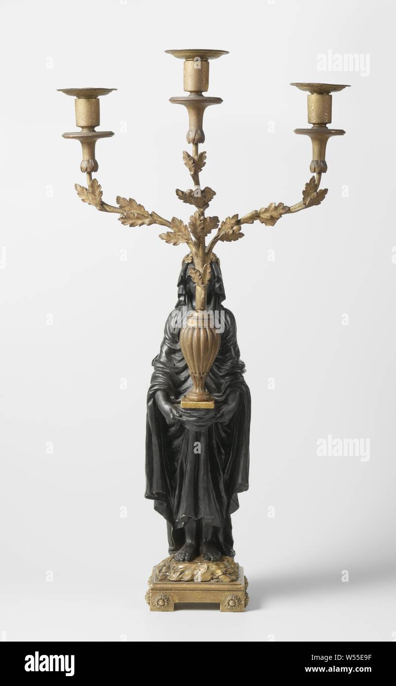 Kandelaber Kandelaber in der Form einer verschleierten Vestalin, drei Arme, eine hölzerne Stehende weibliche Figur auf einem quadratischen Sockel. Sie trägt ein Drei-light Armleuchter, die aus einer Vase auf einem quadratischen Sockel kommt. Die Arme der Armleuchter werden in Form von Eiche. Die bobèche ist lose. Die Frau ist schwarz lackiert und der Rest ist vergoldet. Paté Schicht an einigen Stellen beschädigt ist, vor allem an den Kerzenständer, Vestalin (s), anonyme, Niederlande, C. 1780 - C. 1800, Holz (Pflanzen), Farbe (Beschichtung), Messing (Legierung), Komposition (Material), Vergoldung Stockfoto
