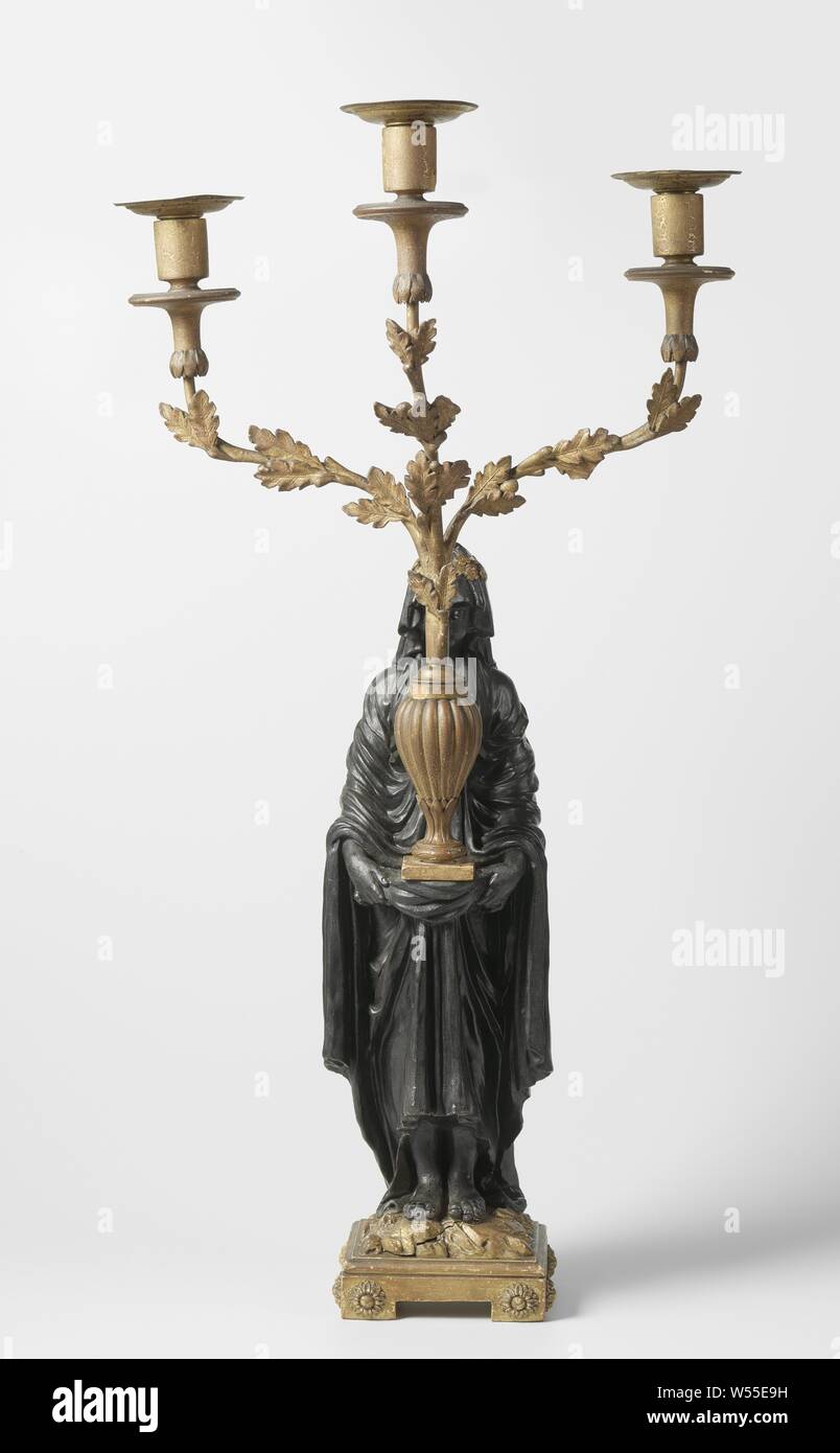 Kandelaber Kandelaber in der Form einer verschleierten Vestalin, drei Arme, eine hölzerne Stehende weibliche Figur auf einem quadratischen Sockel. Sie trägt ein Drei-light Armleuchter, die aus einer Vase auf einem quadratischen Sockel kommt. Die Arme der Armleuchter werden in Form von Eiche. Die bobèche ist lose. Die Frau ist schwarz lackiert und der Rest ist vergoldet. Paté Schicht an einigen Stellen beschädigt ist, vor allem an den Kerzenständer, Vestalin (s), anonyme, Niederlande, C. 1770 - C. 1800, Holz (Pflanzen), Messing (Legierung), Farbe (Beschichtung), Komposition (Material), Vergoldung Stockfoto