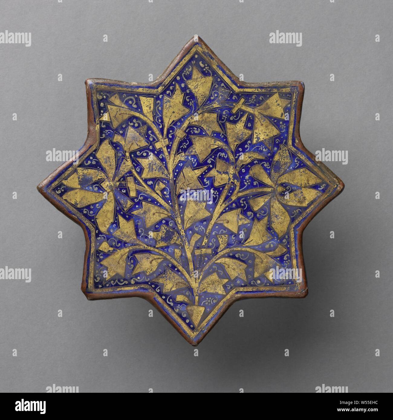 Sternförmige Fliese mit einem stilisierten blühende Pflanze, sternförmige Fliese mit einem stilisierten Pflanze (Lotus) und floralen Motiven in Gold auf einem kobaltblauen Hintergrund. Ladjvardina., anonym, Iran, C. 1250 - C. 1299, Steingut, Glasur, Cobalt (Mineral), Gold (Metall), Verglasung, t 1,9 cm × d 20,1 cm Stockfoto