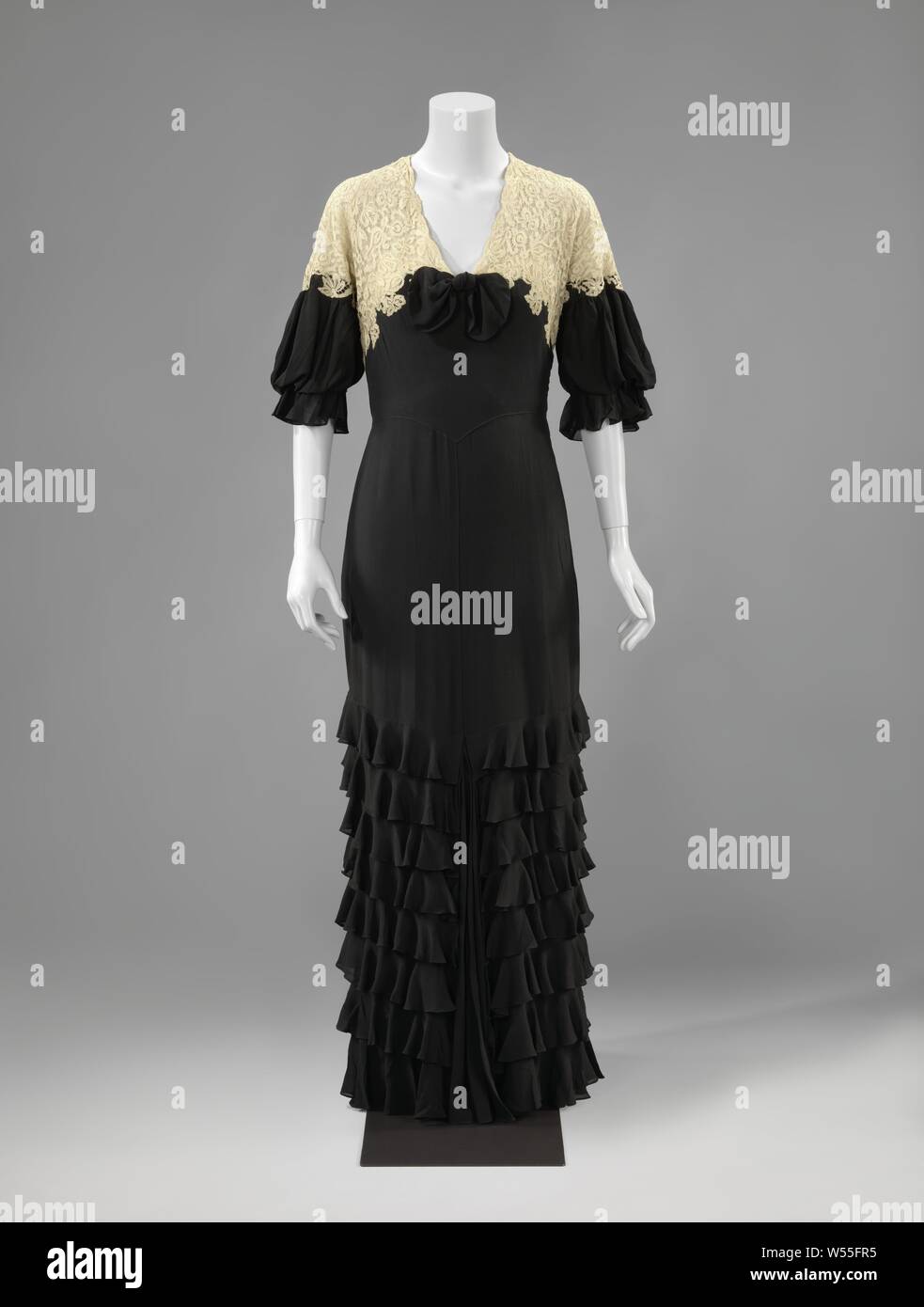 Abendkleid schwarz Crêpe Georgette und natürlichen Farben Maschine Spitze, lang und leicht ziehen, mit zerknitterten Streifen Crêpe Georgette, abendkleid schwarz Crêpe Georgette und naturfarbene Baumwolle Spitze, mit zerknitterten Streifen Crêpe Georgette eingerichtet. Modell: glatt mit Taille in der Front auf dem Vorderteil und endet mit einem Punkt. Aus zwei glatte Rock Gebäude mit einem Split in der Mitte, in der Plissee crepe Georgette. Die weiche Rückseite, ausgeführt wird und endet in einer Kellerfalte. Halbe Länge puffing Ärmel, endet in einem Tunnel mit einem zerknitterten Streifen. Schließung in der Linken Stockfoto