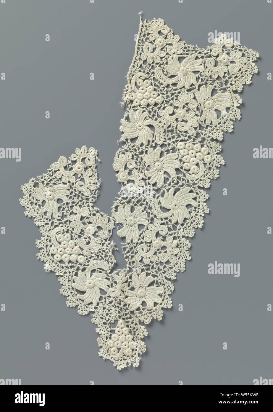 Fragment gehäkelter Spitze mit Blumen und Trauben, V-förmige Teil eines natürlichen Irischen gehäkelter Spitze. Muster mit Blumen und Trauben und einem gestricken unregelmäßigen Gitter mit Picots. Auf der Außenseite, die halbrunde Jakobsmuscheln mit iconic Bogen gesetzt. Die verschiedenen Teile der Kanten sind noch nicht abgeschlossen und/oder geschnitten oder getrimmt., anonym, Ierland (möglicherweise), C. 1890 - C. 1909, Baumwolle (Textil), l 30 cm × w 10,5 cm Stockfoto