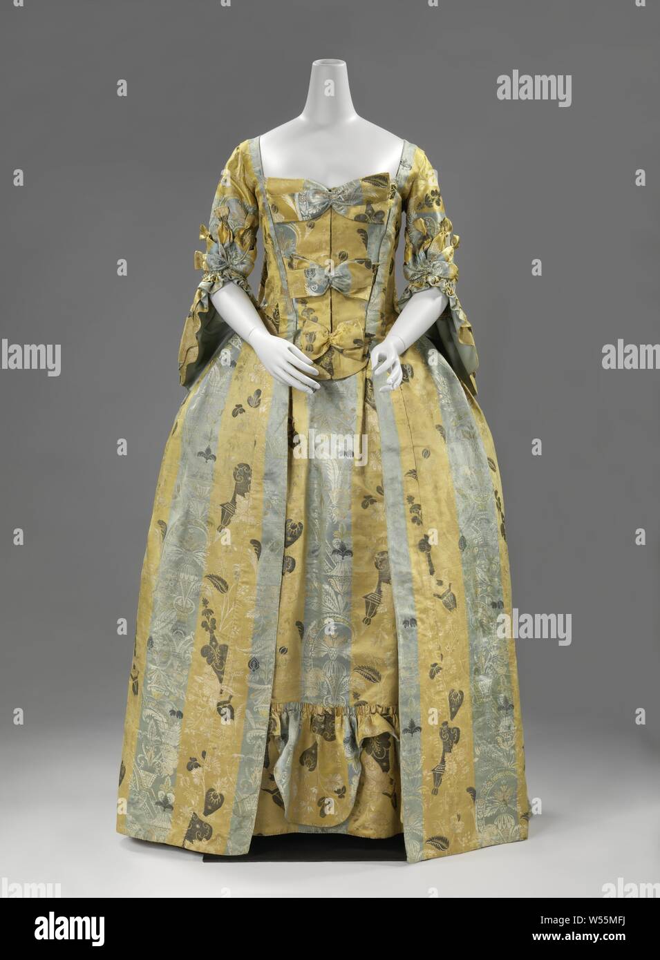 Mantel der grau-blau-gelb gestreiften Lampas, mit gewebten bizarre Muster besteht aus Vasen mit Blatt- und Blumenmotiven und geometrischen Figuren bestickt mit Metalldraht, Modell: gerader Ausschnitt, halbe Länge enganliegenden Ärmeln mit einem Bogen - wie Dekoration und mit doppeltem Pagode - geformte Manschetten (Manschetten und eventail), eng anliegende Körper an der Vorderseite mit Brusttasche 1957 hinzugefügt und aus zwei Teilen ausgestattet mit drei Bögen (l'Echelle), eine lose, symmetrische Struktur der gelegten Falten auf der Rückseite vom Hals (pl Watteau), die vorderen Teile von Rock glatt und mit konischen Spitzen Stockfoto
