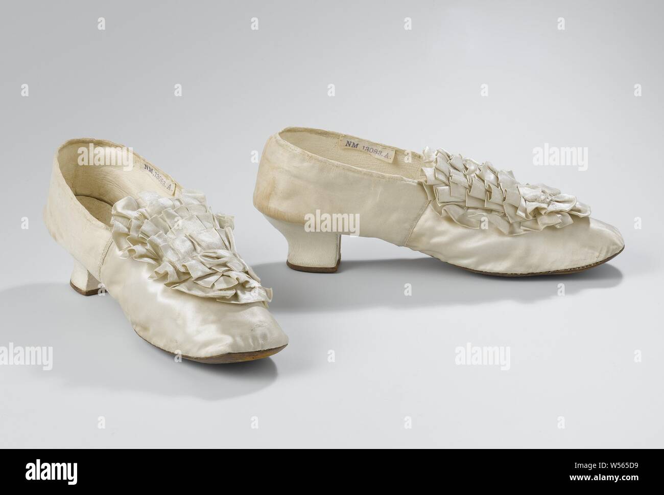 Frauen schuh in Ivory White Satin mit Rosette auf der Vorderseite des Siebkastens und Square Nase, Schuh der Frauen in Ivory White Satin. Modell: Die Nase ist eine Vorder- und eine Rückseite. Die Vorderseite der Ferse läuft gerade nach unten. Der Seite und Rückseite der Ferse angebracht sind und mit Ivory White Satin mit dunkelbraunem Leder Rand der Rückseite gesäumt. Zurück mit drei Nägeln an die Ferse und Sohle aus echtem Leder und Leder gebunden. Hintere Abdeckung, gesäumt mit Elfenbein Weiß Leder, vordere Abdeckung, gesäumt mit Elfenbein Weiß gerippt Baumwolle. Die Innensohle ist Elfenbein Weiß Leder. Dekoration: Ivory White Satin Rosette in der Mitte der vorderen Abdeckung. Unter Stockfoto