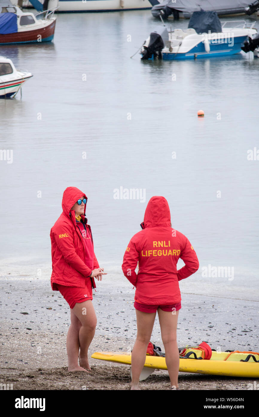 Zwei weibliche R.N.L.I Rettungsschwimmer an einen britischen Badeort, Großbritannien, Großbritannien Stockfoto