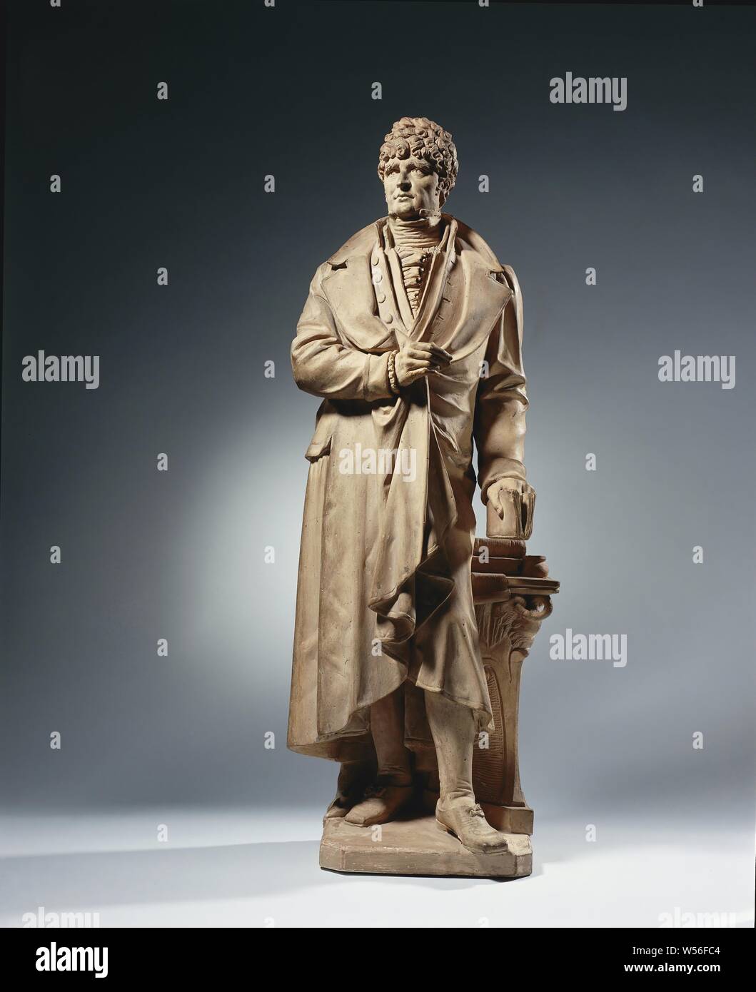 Willem Bilderdijk (1756-1831), die er auf einem Sockel auf dem rechten Bein und mit dem vorderen linken steht. Den Kopf leicht nach links gedreht wird, schaut er vorn in Gedanken. Mit der rechten Hand hält er die Zerschlagenen Mantel unter der Brust, während Sie eine Gans Stift in der Hand, im hängenden Linken er ein Buch mit dem Zeigefinger zwischen den Seiten hält. Rechts von ihm ist ein 3-seitig taburet mit einem Quadrat oben (sic.), auf der zwei Bücher neben einem Tinte gut liegen, gibt es eine Eisstockbahn Papier unter Bücher und eine Wolldecke hängend auf der Rückseite. Die taburet erinnert an einen Römischen altar Stockfoto