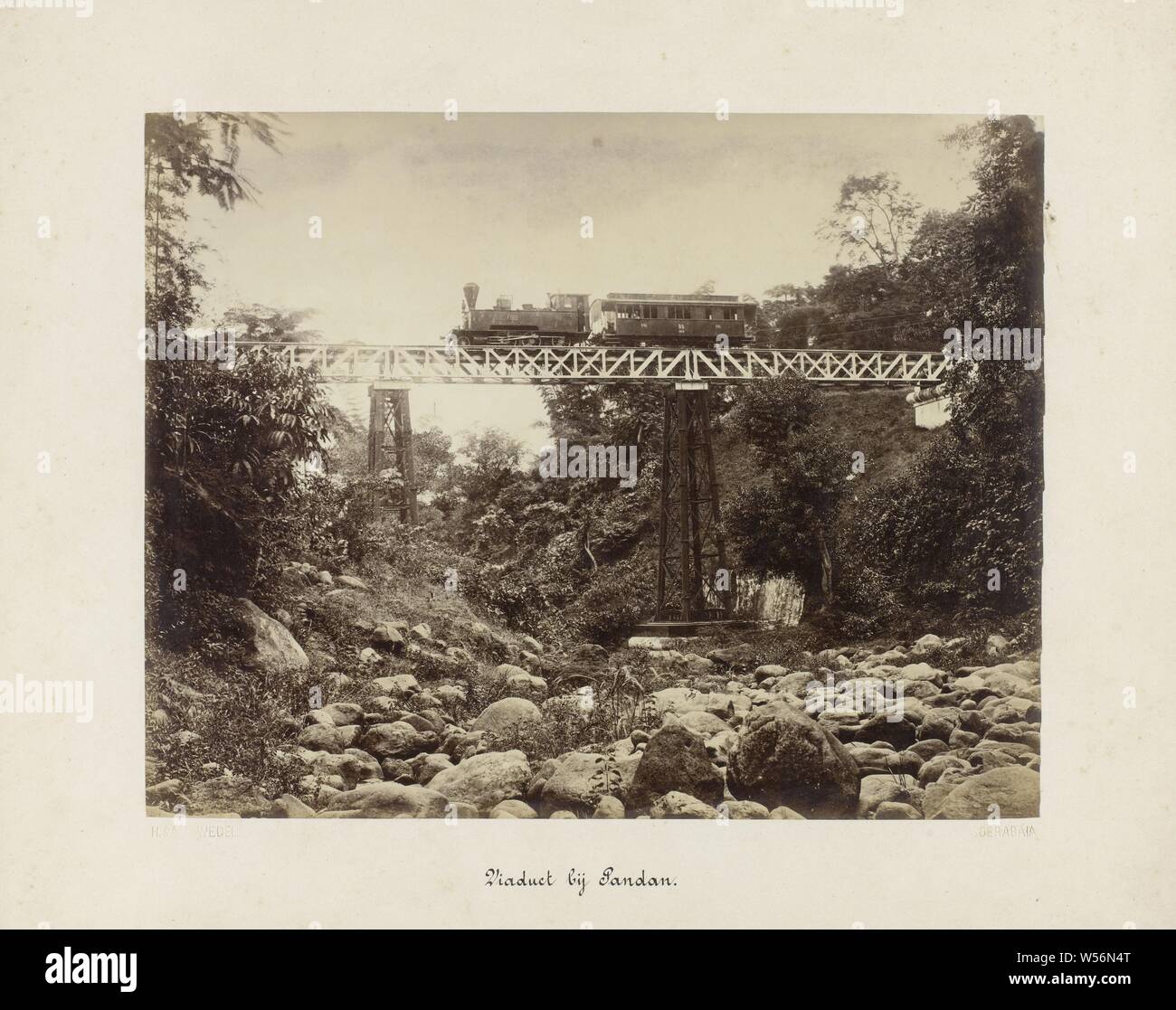 Viadukt in der Nähe von Pandan (Titel auf Objekt) Staatsbahn in Java (Titel der Serie), ein Viadukt oder Eisenbahn Brücke über eine Schlucht oder einem trockenen Flussbett in der Nähe von Pandan. Es ist ein Zug, der mit einem Pkw auf der Brücke. Teil einer Gruppe von 62 Fotos in einer Schachtel mit der Aufschrift 'State Eisenbahnen auf Java" aus dem Jahre 1888, Sandan, Herman Salzwedel (auf Objekt erwähnt), Surabaya, 1880 - 1888, Fotopapier, Eiklar drucken, H 215 mm x B 275 mm H 300 mm x B 370 mm Stockfoto