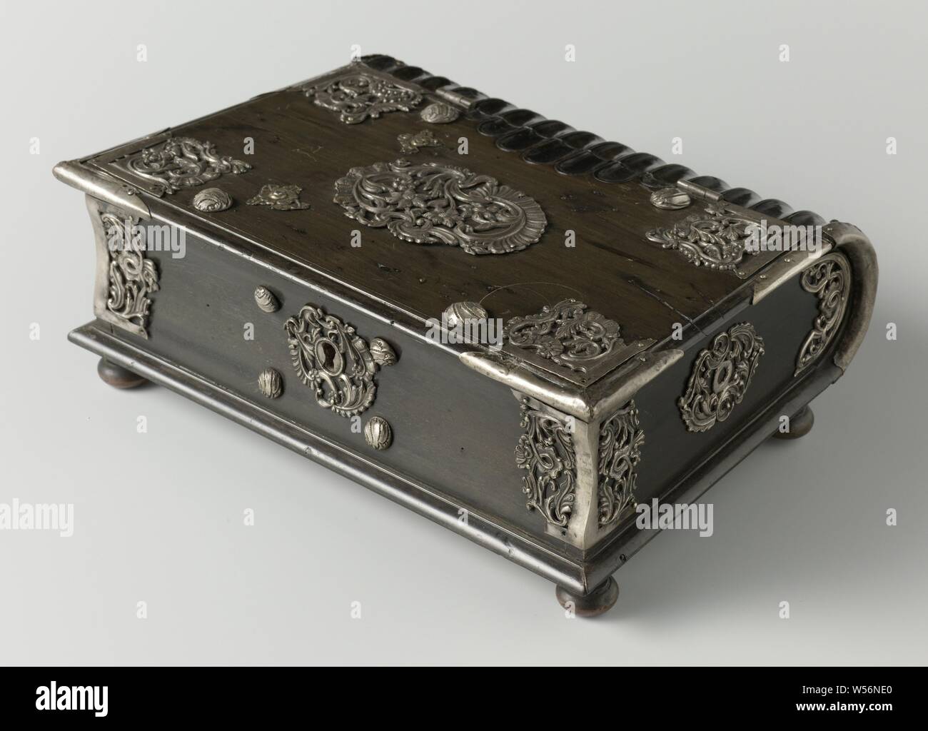 Kassette in Buchform, Kassette in Buchform auf 4 runden, flachen Beine. Die Ecken silber Innenausstattung im Rokoko Muster. Auf dem Deckel, ähnlich wie Teig von röschen umgeben. Silver Fittings mit shell Motiv, einschließlich auf der Sicherungsplatte. Die Rückseite der Kassette ist gerippt, wie ein Buch. Schlüssel fehlt, Buch, fantasy Ornament, Sri Lanka, Niederländisch Ostindien, der Niederländischen Ostindien-Kompanie, anonym, Indonesien, 1750 - 1774, Ebenholz (Holz), Silber (Metall), kupfer (Metall), Gravieren, h7cm x W 24 cm x d 17 cm Stockfoto