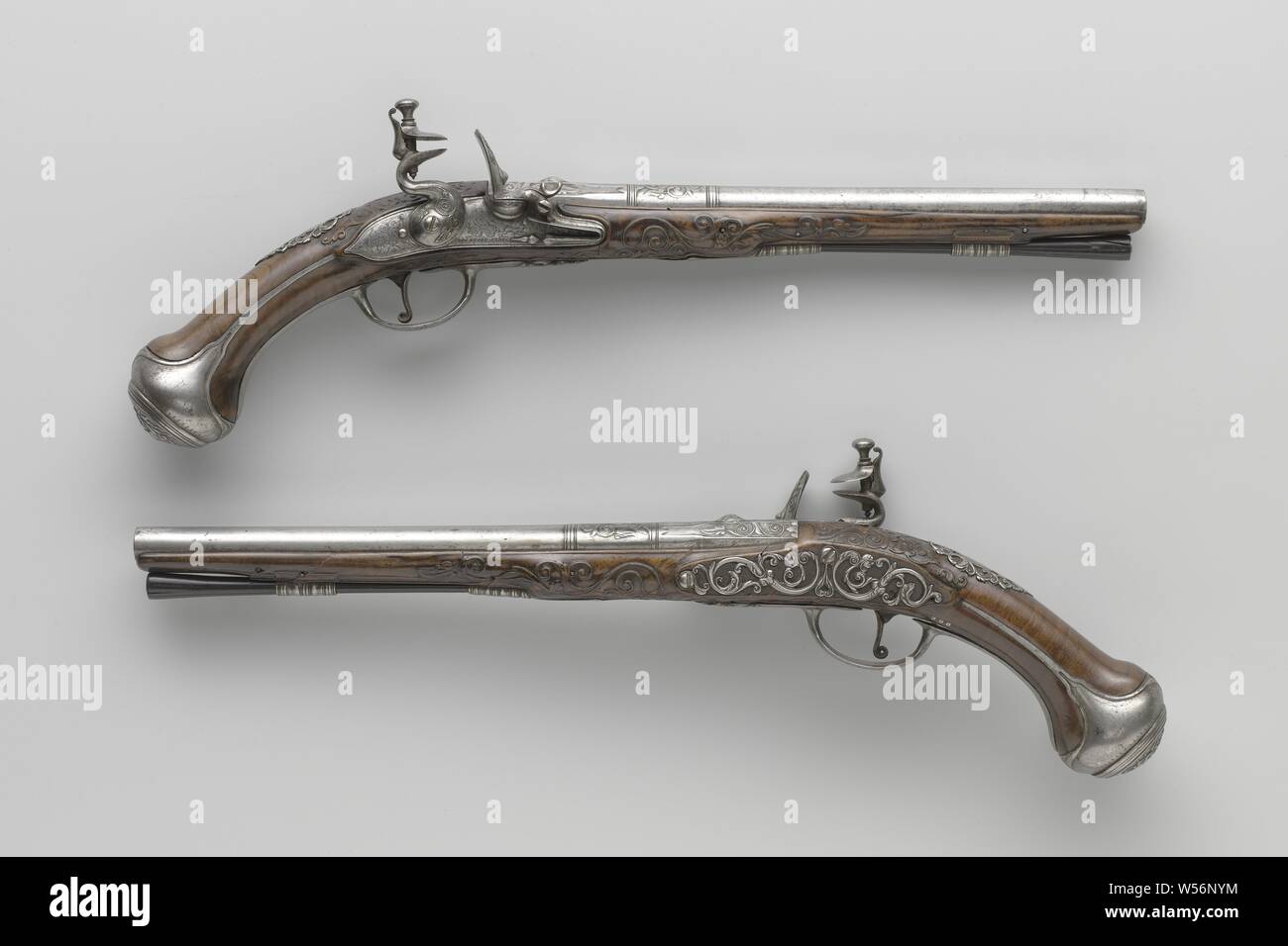 Paar flintlock Pistolen Flintlock Pistol, Teil eines Paares zu sein. Der Hahn und das Feuer stahl des Schlosses sind mit Blättern geprägt, die Sicherungsplatte ist mit lofwerk eingraviert, Amor mit Pfeil und Bogen, Cybele in einem Warenkorb von einem Löwen mit vier Rädern und die Signatur erstellt. Den Zylinder mit zwei Paar Ringe als Trennwand zwischen den verschiedenen Teilen der Zylinder vorhanden ist, wird der Lauf ist auf der Rückseite mit Laub um die hinteren Visier gemeißelt wie eine groteske Maske gemeißelt, auf der Unterseite in die Arme von Utrecht gestempelt unter unleserliche Zeichen, vielleicht eine Rosette. Die Wurzelnuss lieferbar ist Stockfoto