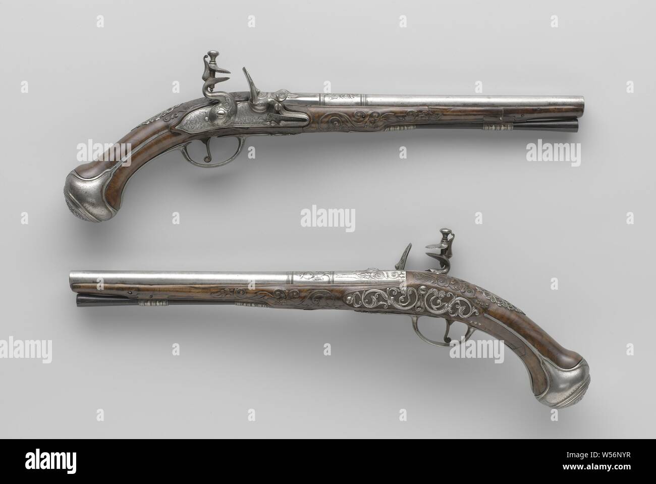 Paar flintlock Pistolen, Musketen Pistole, Teil eines Paares zu sein. Der Hahn und das Feuer stahl des Schlosses sind mit Blättern geprägt, die Sicherungsplatte ist mit lofwerk eingraviert, Amor mit Pfeil und Bogen, Cybele in einem Warenkorb von einem Löwen mit vier Rädern und die Signatur erstellt. Den Zylinder mit zwei Paar Ringe als Trennwand zwischen den verschiedenen Teilen der Zylinder vorhanden ist, wird der Lauf ist auf der Rückseite mit Laub um die hinteren Visier gemeißelt wie eine groteske Maske gemeißelt, auf der Unterseite in die Arme von Utrecht gestempelt unter unleserliche Zeichen, vielleicht eine Rosette. Die Wurzelnuss lieferbar ist Stockfoto