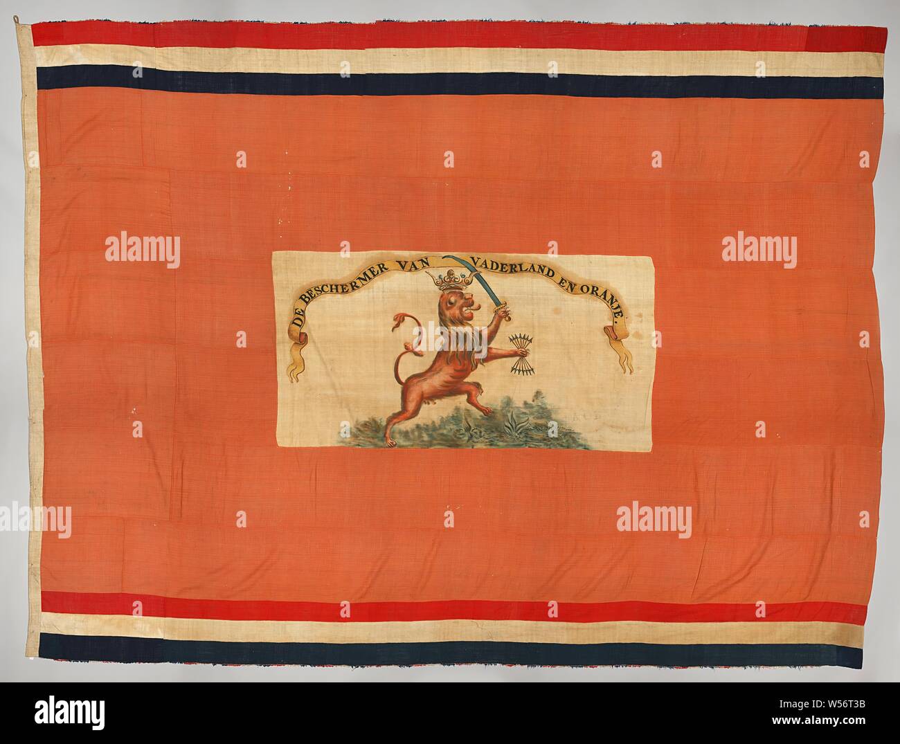 Niederländischer Flagge, Orange Flagge, in der Mitte ein Rechteck, in dem eine rote klettern Löwe mit Krone und Profil auf der rechten Seite, mit krummsäbel und Rod Bundle (die Pfeile haben einen Punkt an beiden Enden), stehend auf einer grünen Kreis. Über eine Banderole, auf die in der klassischen Hauptstädte: DER BESCHÜTZER DER VADERLAND UND ORANGE. Schmale Linien der rot-weiß-blau mit kurzen Schnickschnack der rot-weiß-blau am oberen und unteren Bildrand. Auf den Hosen: TR. 53.1953.N. O. M, Niederlande, anonym, C. 1840, Baan rood en Blauw, Baan Witz, Malerei, h 337 cm x W445 cm Stockfoto