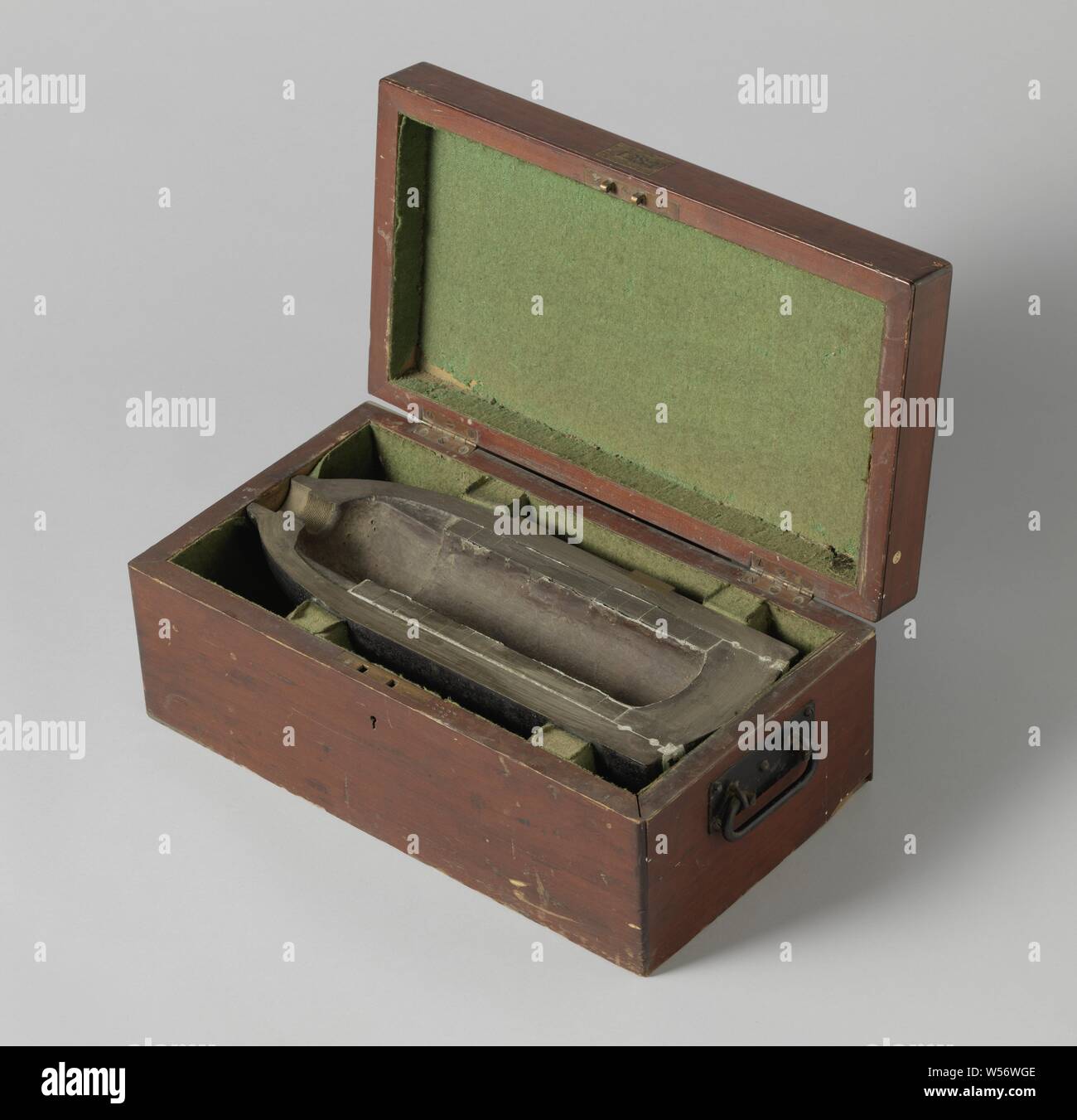 18-cm-Schale in eine Holzkiste, Segment, einem halben Punkt-förmige 18 cm Granate gesägt in der Hälfte, in einer Holzkiste. Die Granate ist 45 cm lang und hat ein Kaliber von 176 mm. Er hat zwei Ringe aus Bronze Nocken für einen gezogenen Lauf mit drei wandernden Felder. Die Nase hat die Form eines Flaschenhalses mit einem Rohr Bohrung. Die Granate ist hohl: Die explosiven Ladung wird durch zwölf Bügeleisen segment Ringe, die zusammen mit Lead geklebt sind umgeben. Die Unterseite ist auch mit führen Ringe angebracht., W. G. Armstrong & Co., Newcastle upon Tyne, 1868, Eisen (Metall), Bronze (Metall), Messing (Legierung), Holz (Pflanzen), Shell: h 8,8 Stockfoto