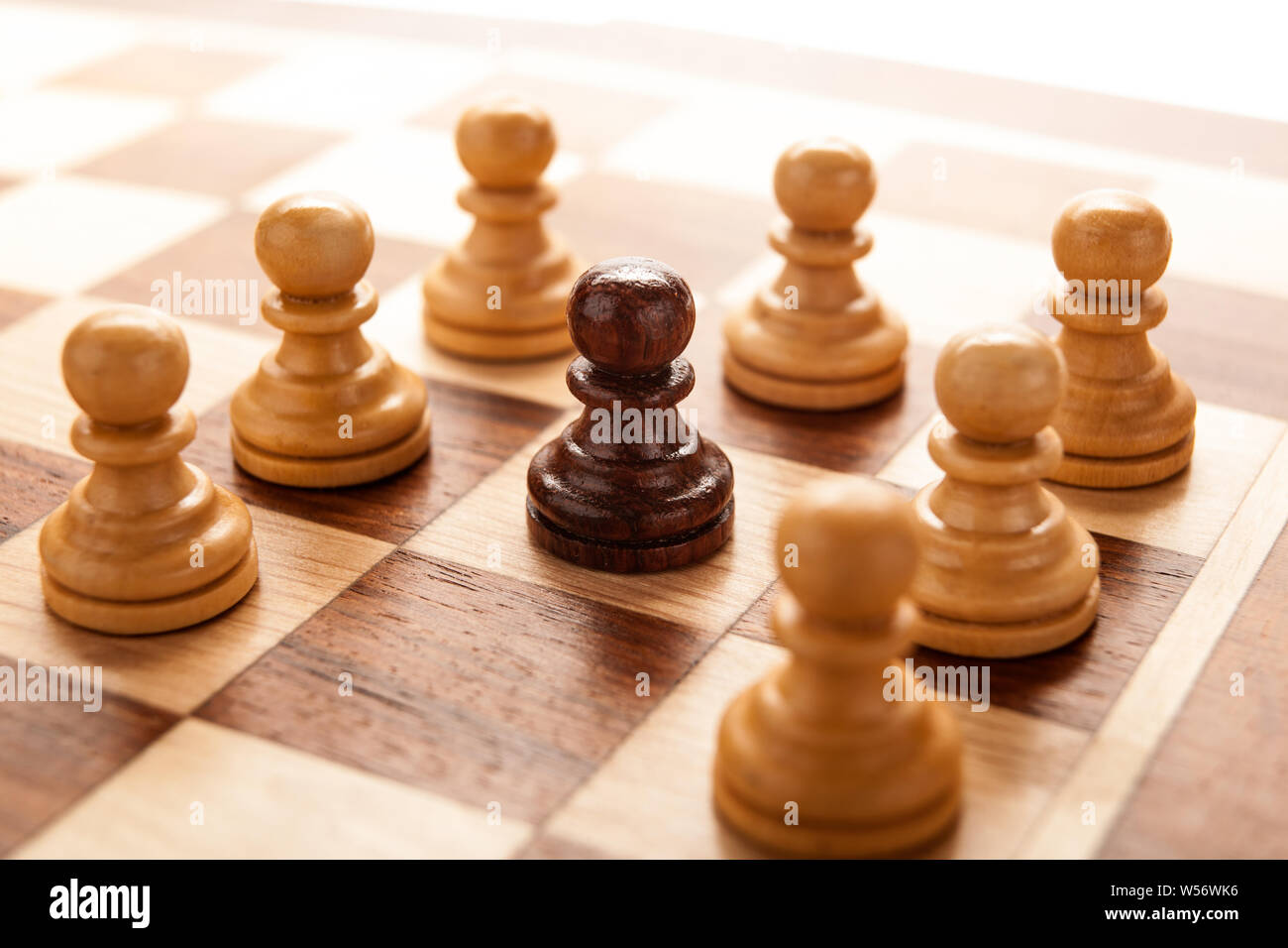 Schwarz schach Schachfigur umgeben von weißen Schach Schachfiguren Stockfoto