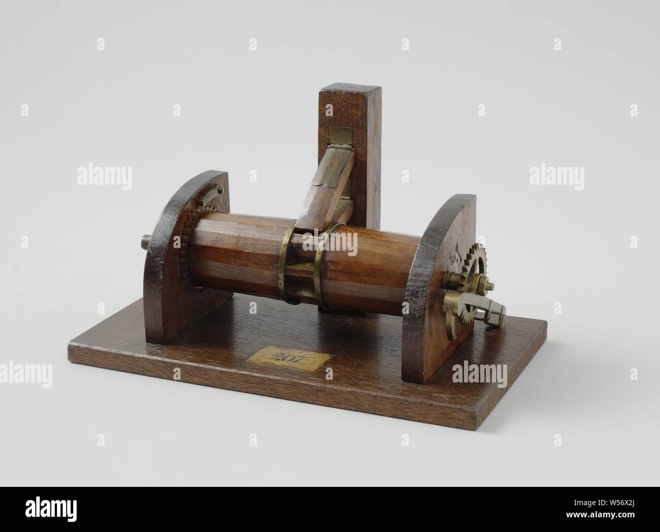 Modell einer Ankerwinsch, Modell eines rösten Spindel auf einer Diele. Die Trommel, die zwischen zwei Wangen ausgesetzt ist, hat keine Löcher für Windenergie boomt: Die Röstung Spindel ist mit einem einzigen Wind boom auf der steuerbord Wange, die ein Zahnrad mit einer Sperrklinke einrastet. In der Mitte gibt es eine Stütze mit zwei hölzernen Fänge, die in den Gang Teil der Trommel es gegen Zurückrollen. Ein zusätzliches Kettenrad mit Haken ist, gegen den Hafen Wange ausgestattet. Maßstab 1:10 (Schätzung)., anonym, Niederlande, C. 1850, Holz (Pflanzen), Messing (Legierung), h 18,2 cm x W 30,5 cm x T 16,5 cm Stockfoto
