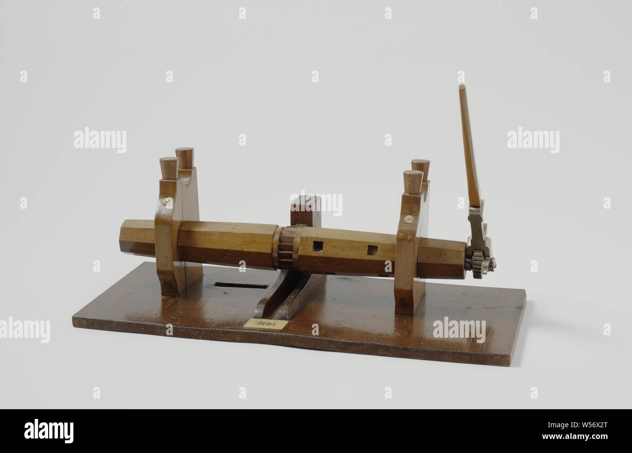Modell einer Ankerwinsch, Modell eines rösten Spindel auf einer Diele. Die Trommel, die zwischen zwei Wangen, die Röstung Spindel bilden mit zwei Diener jeder ausgesetzt ist, nur über Steuerbord Löcher für Wind Bäume: Zwei durchgehende und vier flache Bohrungen. Die Röstung Spindel kann auch mit einem einzigen wind Baum auf der Steuerbordseite, die greift in ein Ritzel mit einer Sperrklinke betrieben werden. In der Mitte gibt es eine Stütze mit zwei hölzernen Fänge, die in den Gang Teil der Trommel es gegen Zurückrollen. Das Backen oder Braten Spindel kann jeder in zwei Hälften auseinander genommen werden. Es ist ein rechteckiges Loch in Stockfoto