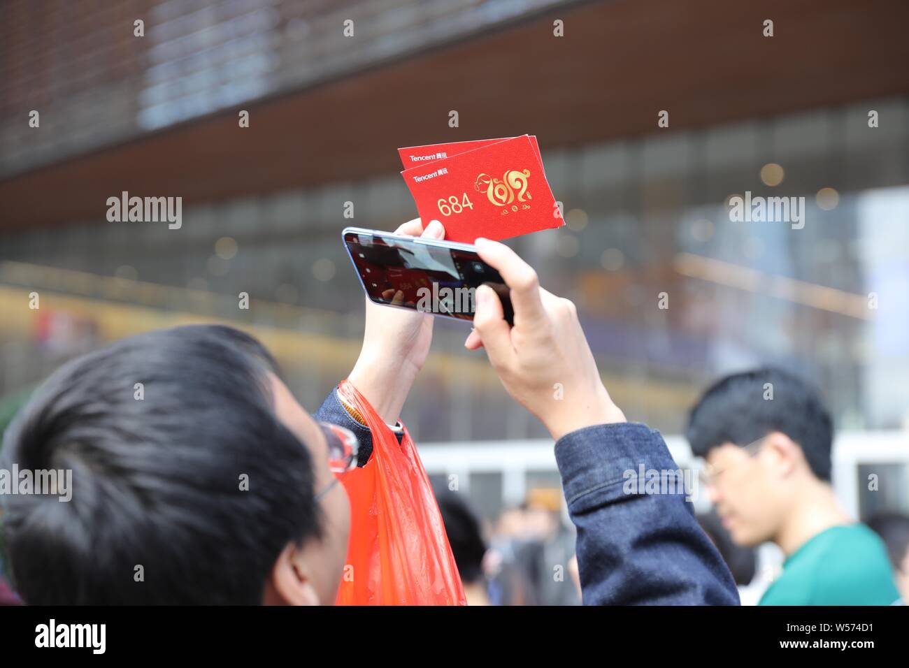 Ein Mitarbeiter der chinesischen Internet Riesen Tencent nimmt Fotos seiner hongbao (rote Umschläge mit Geld Glück) in der Zentrale der Tencent in Shenzhen. Stockfoto