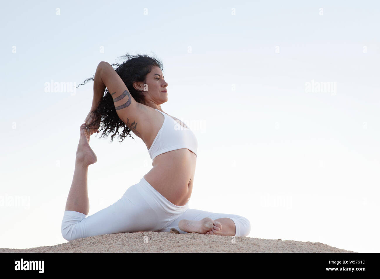 Hispanic Frau im Yoga pose Eka Pada Rajakapotasana Stockfoto