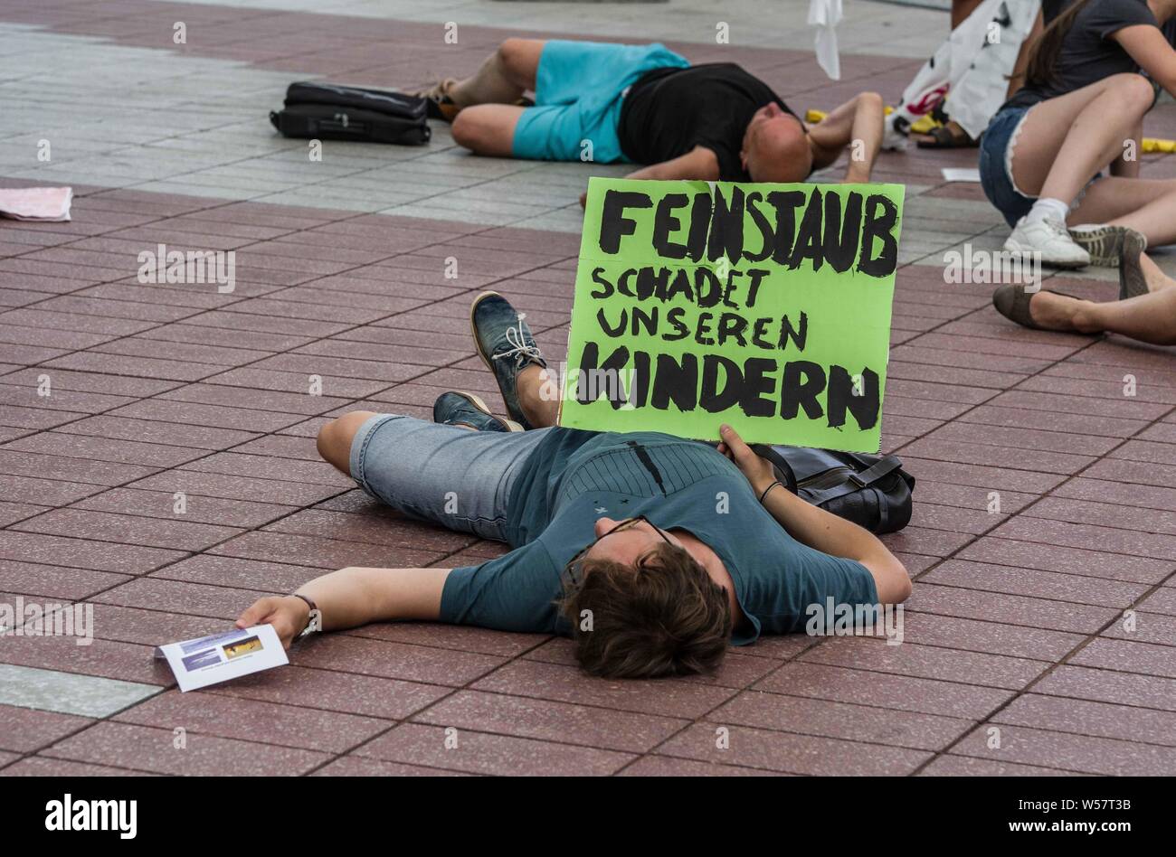 München, Deutschland. 26. Juli 2019. '' Partikel Schäden unsere Kinder'' von einem Aussterben Rebellion sterben in aktivistischen gehalten am Internationalen Flughafen München. Während einer Hitzewelle in Europa, die Broken Records hat, Aktivistinnen aus dem Aussterben Rebellion Gruppe inszenierte ein Sterben in am Flughafen München zu Beginn der Sommerferien, um das Bewußtsein für die Airline, die CO2-Emissionen zu erhöhen. Credit: ZUMA Press, Inc./Alamy leben Nachrichten Stockfoto