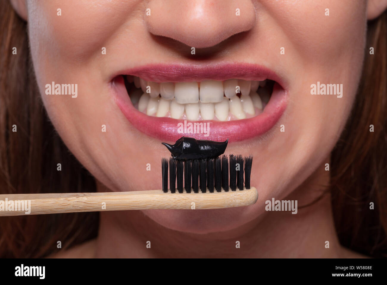 Close-up junge Frau mit Zahnbürste mit schwarzer Aktivkohle Zahnpasta Stockfoto