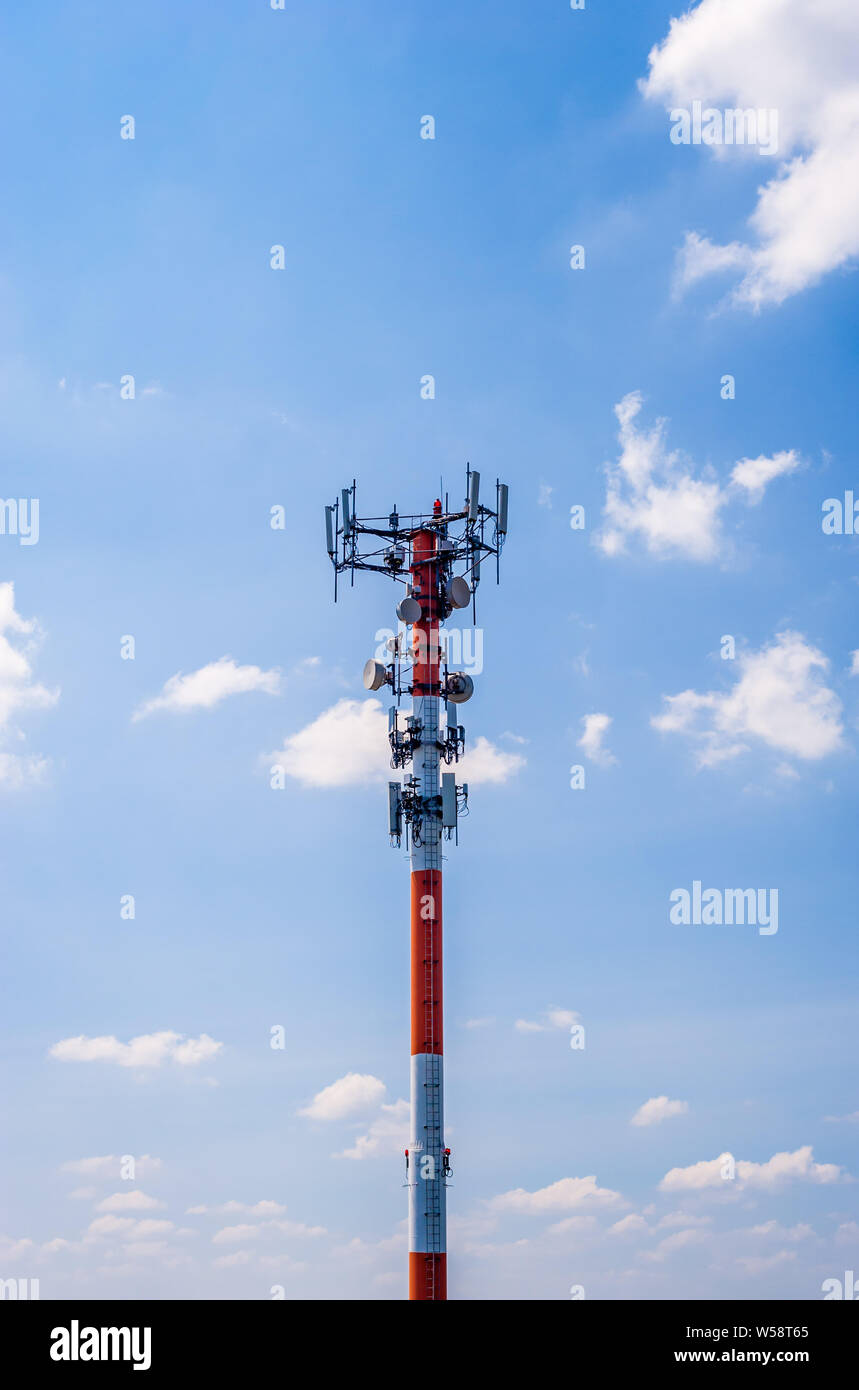 Dicke rote und weiße Metall communications Antenne Turm gegen den blauen Himmel. Stockfoto