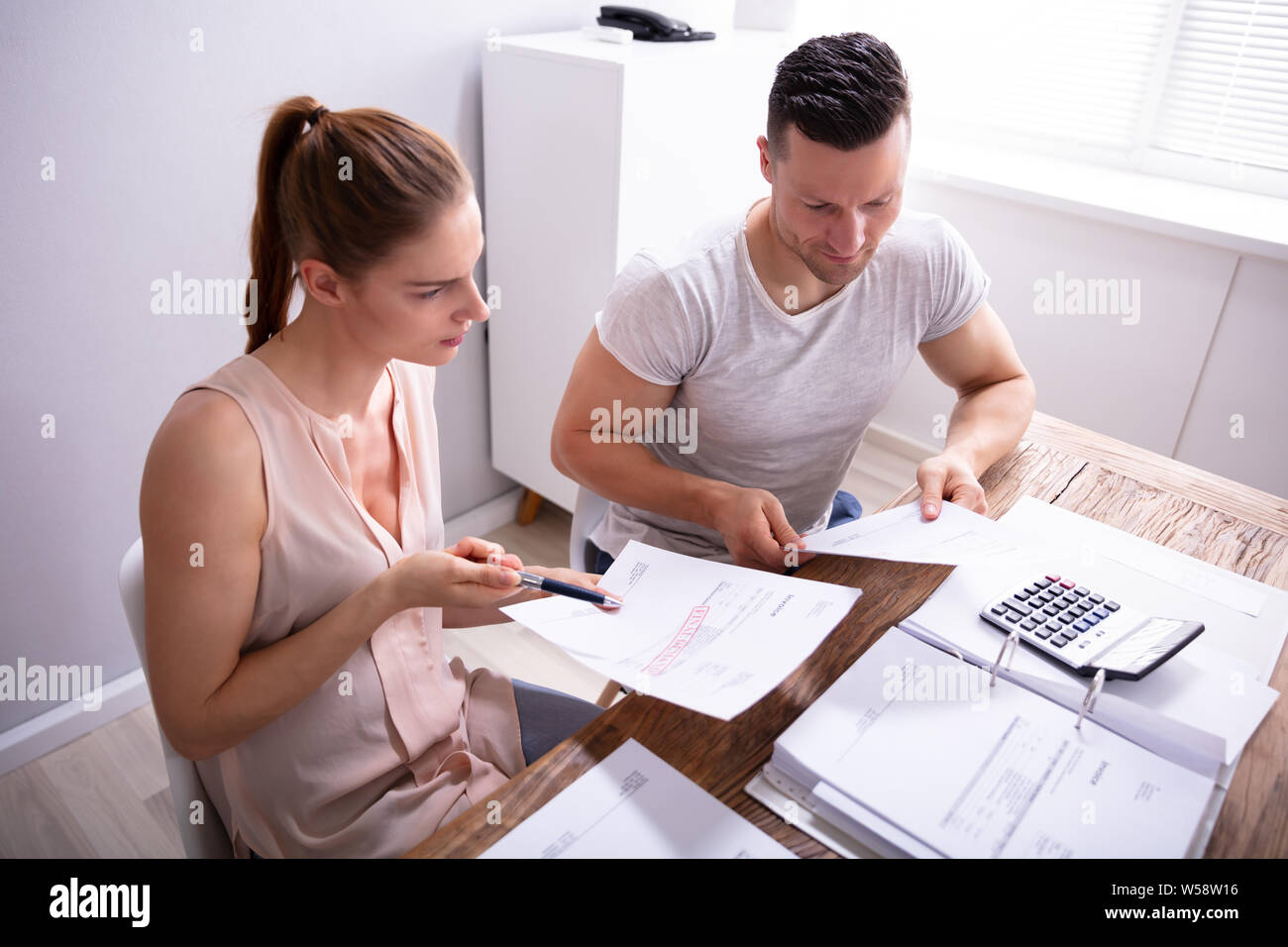 Junge Paare streiten über teure Rechnung zu Hause Stockfoto