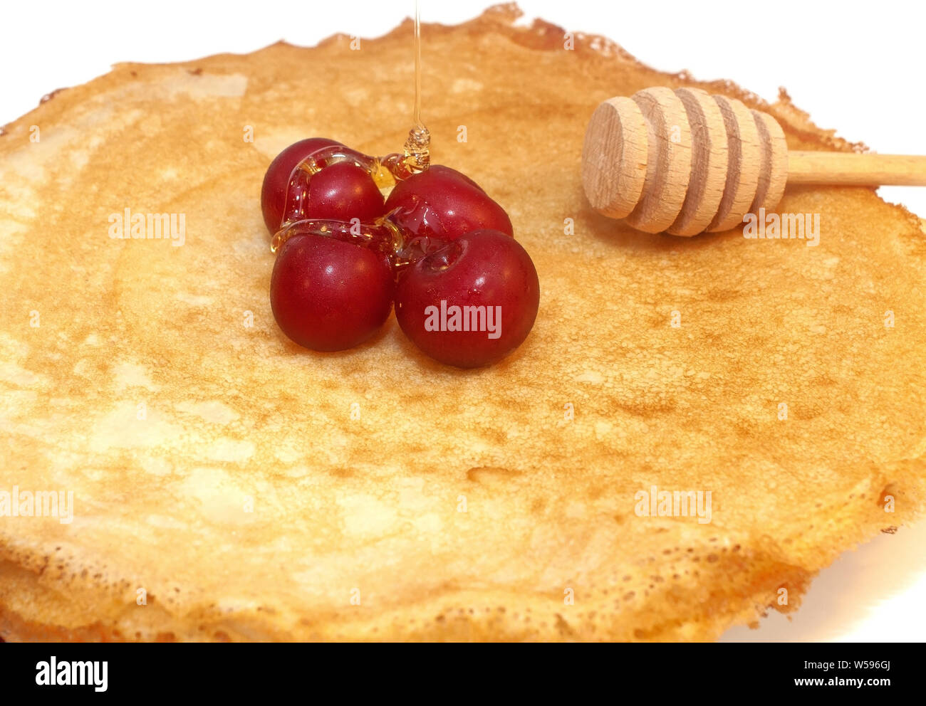 Pfannkuchen zum Frühstück mit Kirschen Beeren isoliert auf weißem Stockfoto