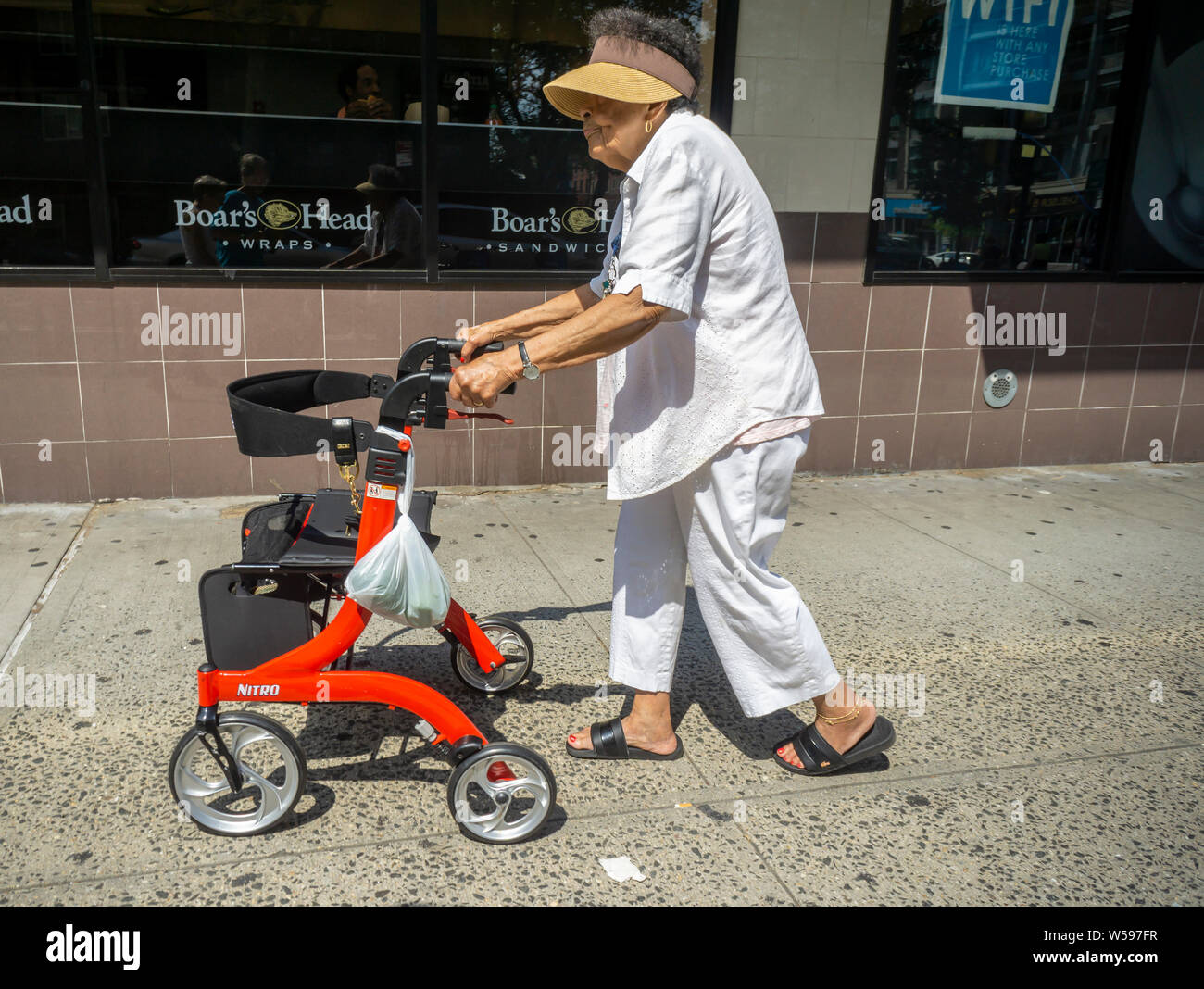 Eine ältere Frau mit der Walker im New Yorker Stadtteil Chelsea am Montag, 22. Juli 2019. (© Richard B. Levine) Stockfoto