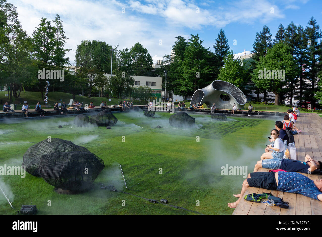 Die kühle Dampf mit japanischer und ausländischer Touristen in Midtown Garten Rasen von Tokyo Midtown, Roppong, Japan, 2019 Stockfoto