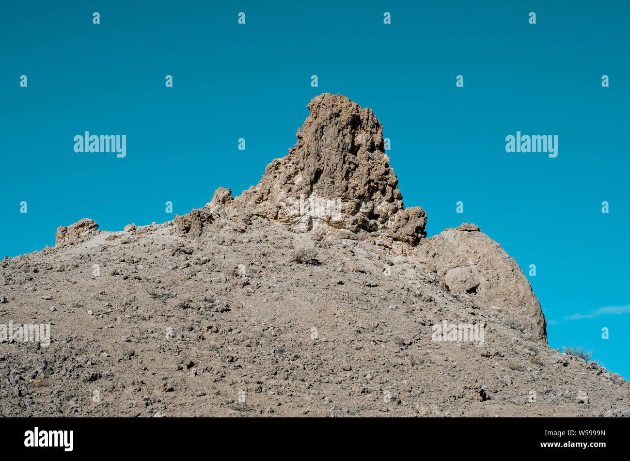 Felsige Hügel mit Rock Formation (Pinnacle) oben erreicht in den blauen Himmel. Stockfoto