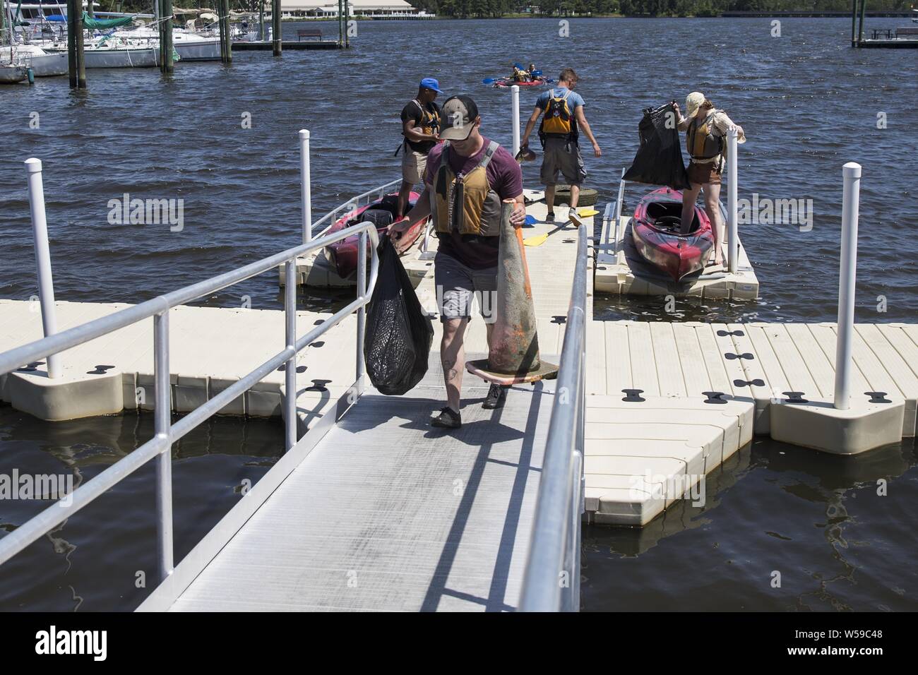 Us-Marines aus dem Marine Corps Air Station New River und Camp Lejeune Rückkehr in die Marina zu entsorgen von Müll aus der Wasserstraße der Gottschalk Marina, Camp Lejeune, N. C, 25. Juli 2019. Juli 25, 2019. In der Bemühung zu halten Camp Lejeune und die Umgebung sauber, die Einzigen Marine Programm organisiert, eine Chance für die Gemeinschaft, zusammen zu kommen, zu sammeln, und richtig von Schutt und Müll, die entlang der Küsten gewaschen entsorgen. (U.S. Marine Corps Foto von Cpl. Tiana Boyd). () Stockfoto