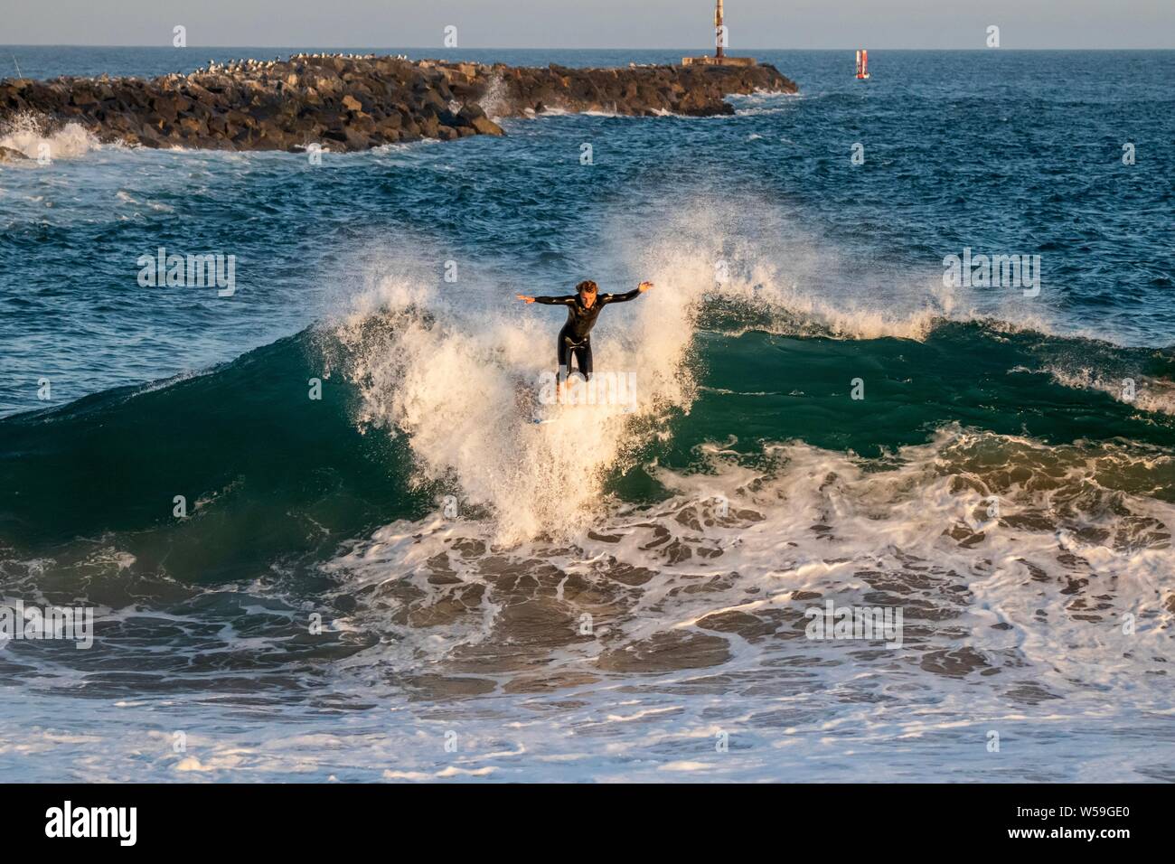 Ein Surfer surft eine große Welle an der Keil in Newport Beach, Kalifornien Stockfoto