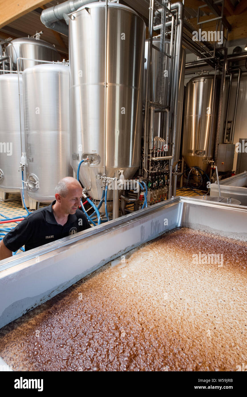 Rambin, Deutschland. 25. Juli, 2019. Braumeister Frank Lucas steuert eine offene Gärung Mwst in der Insel Brauerei. Die kleine handwerkliche Brauerei produziert, nach eigenen Angaben, rund 120.000 3 Liter Flaschen pro Woche - Normale und alkoholfreies Bier. Quelle: Stefan Sauer/dpa-Zentralbild/dpa/Alamy leben Nachrichten Stockfoto