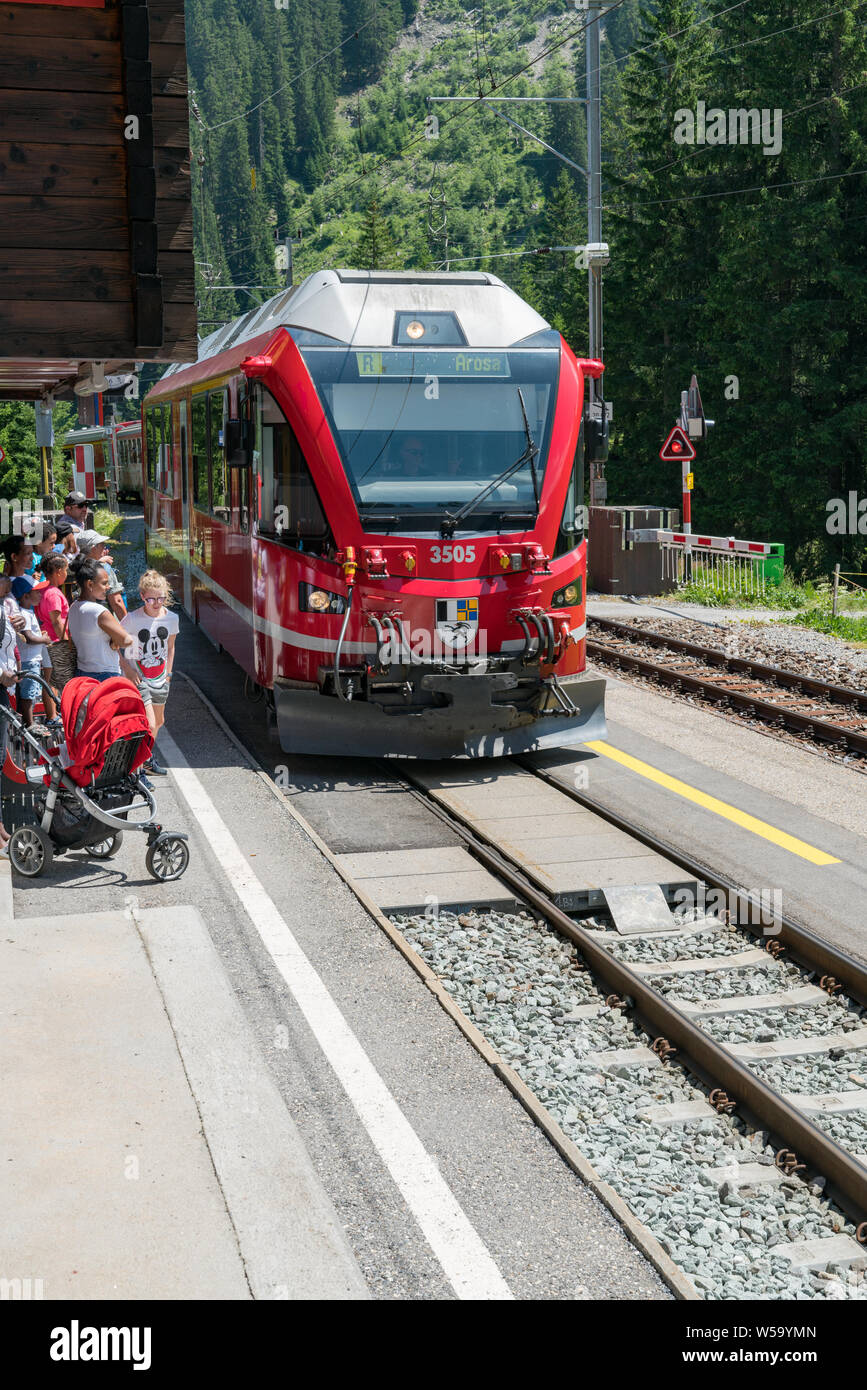 Litzirueti, GR/Schweiz - 24. Juli, 2019: rot Rhatian Bahn Haltestellen in Chur, Fahrgäste entlang der malerischen Chur-Arosa Linie aus Stockfoto