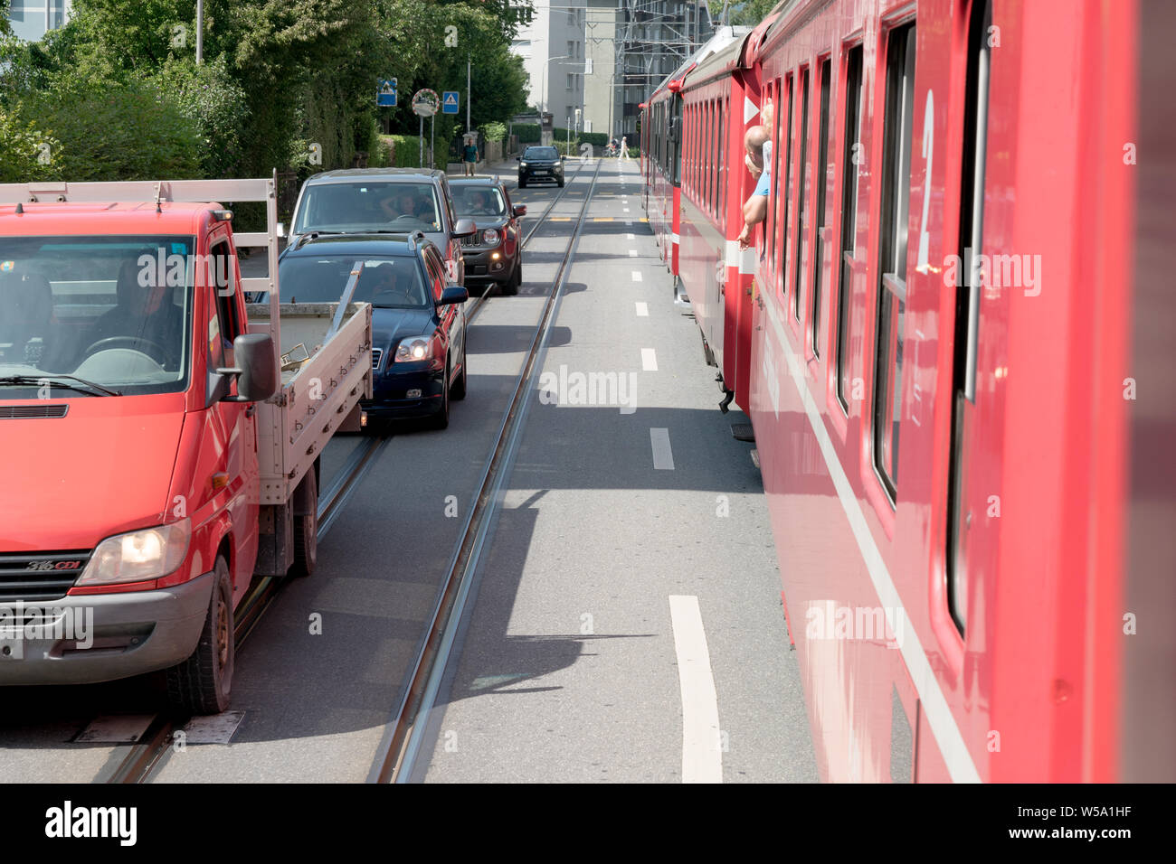 Arosa, GR/Schweiz - 24. Juli, 2019: rot Rhatian Eisenbahn Zug stoppt Verkehr wie fährt er auf den Straßen der Innenstadt von Chur Stockfoto