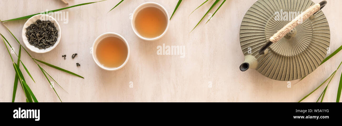 Grüner Tee Zusammensetzung mit Bambus Blätter, Banner. Traditionelle Chinesische Tee, Teezeremonie Konzept, Ansicht von oben, kopieren. Stockfoto