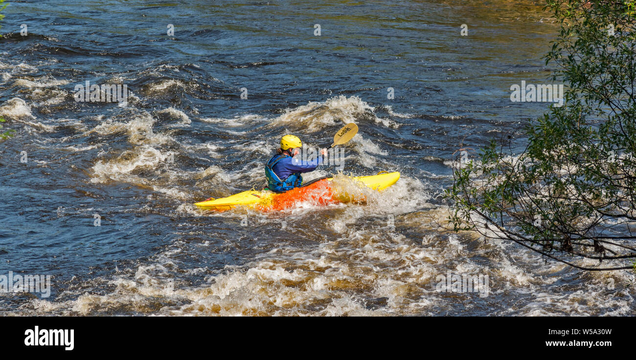 RIVER SPEY SCHOTTLAND GELB UND ORANGE KAJAK und PADDLER IN DER WHITE WATER RAPIDS Stockfoto