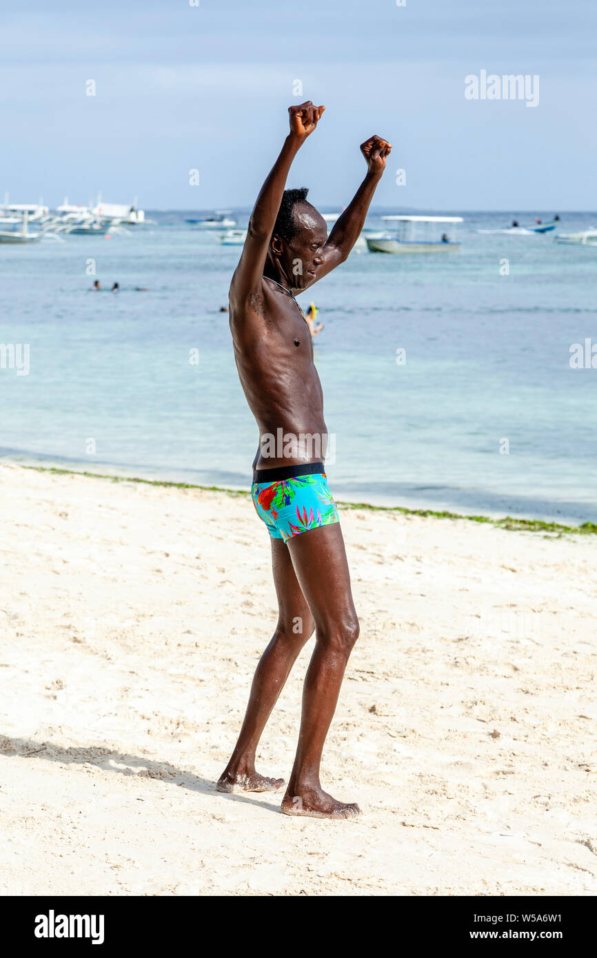 Ein afro-karibischen Mann tanzen auf Alona Beach, Bohol, Philippinen Stockfoto
