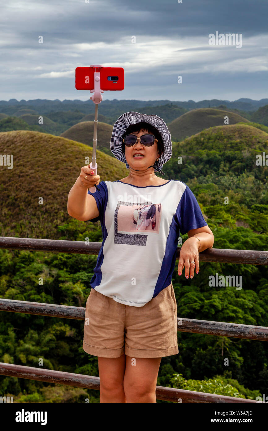 Eine asiatische Frau, eine selfie an der Chocolate Hills Aussichtsplattform, Carmen, Bohol, Philippinen Stockfoto