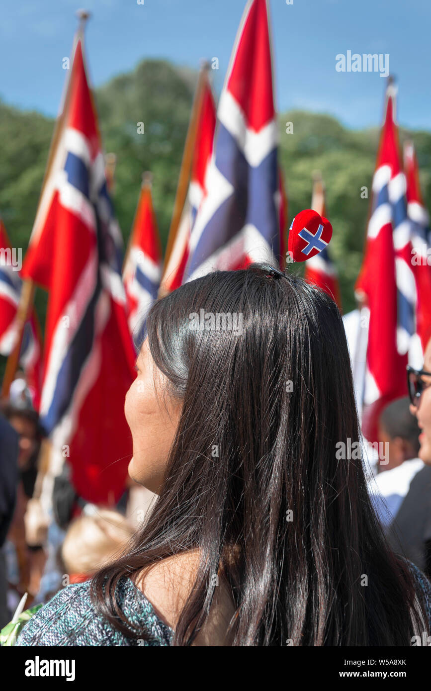 Norwegen, Blick auf eine Frau, die an den Feierlichkeiten zum Nationalfeiertag teilnimmt und einen kühnsten Häppchen in Form einer herzförmigen norwegischen Flagge trägt, Oslo, Norwegen. Stockfoto