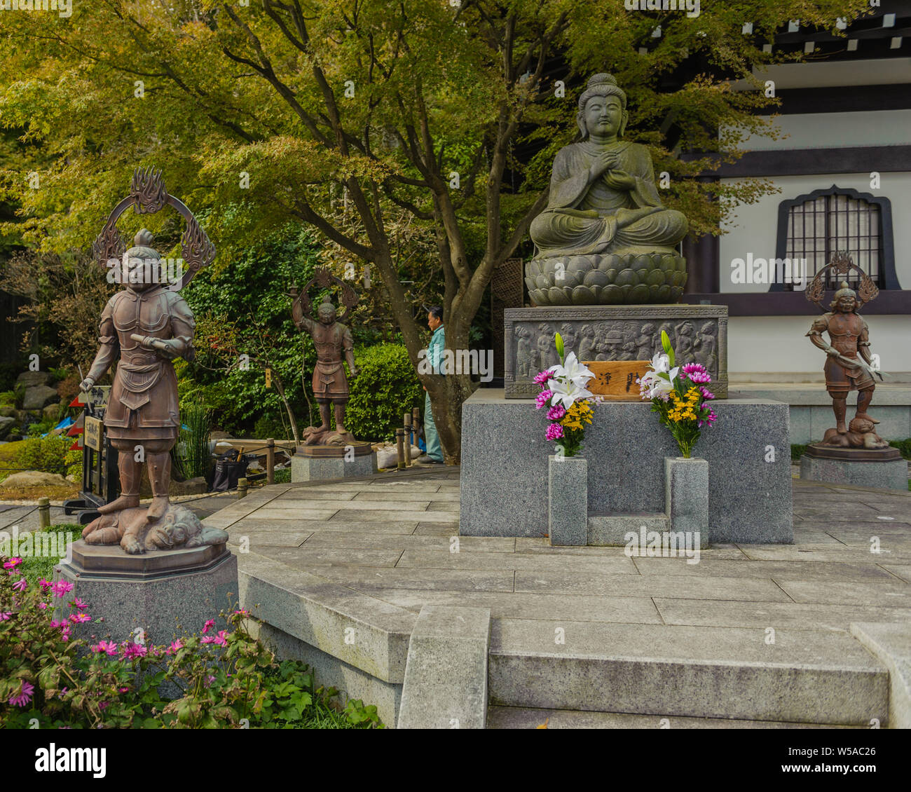 Buddha Statue aus Stein in einem Lotos Sitz auf einer Plattform in Kamakuras Hase-dera Tempel, Japan, November 2018 Stockfoto