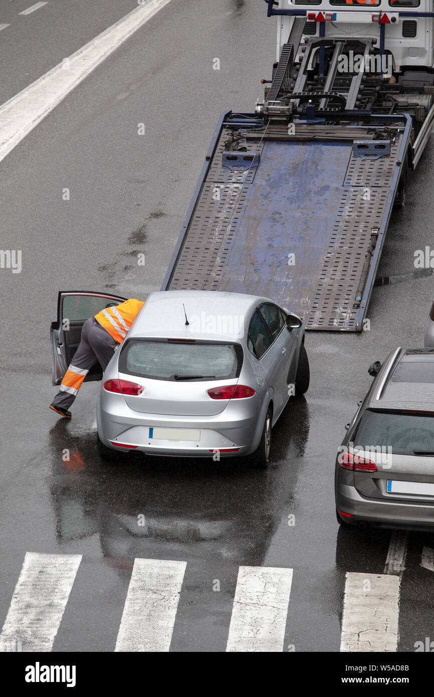 Szene von einem Abschleppwagen mit abgesenkter Plattform bereit, unten gebrochen Auto auf einer Straße der Stadt Straße zu laden. Am Straßenrand Service. Platz kopieren Stockfoto