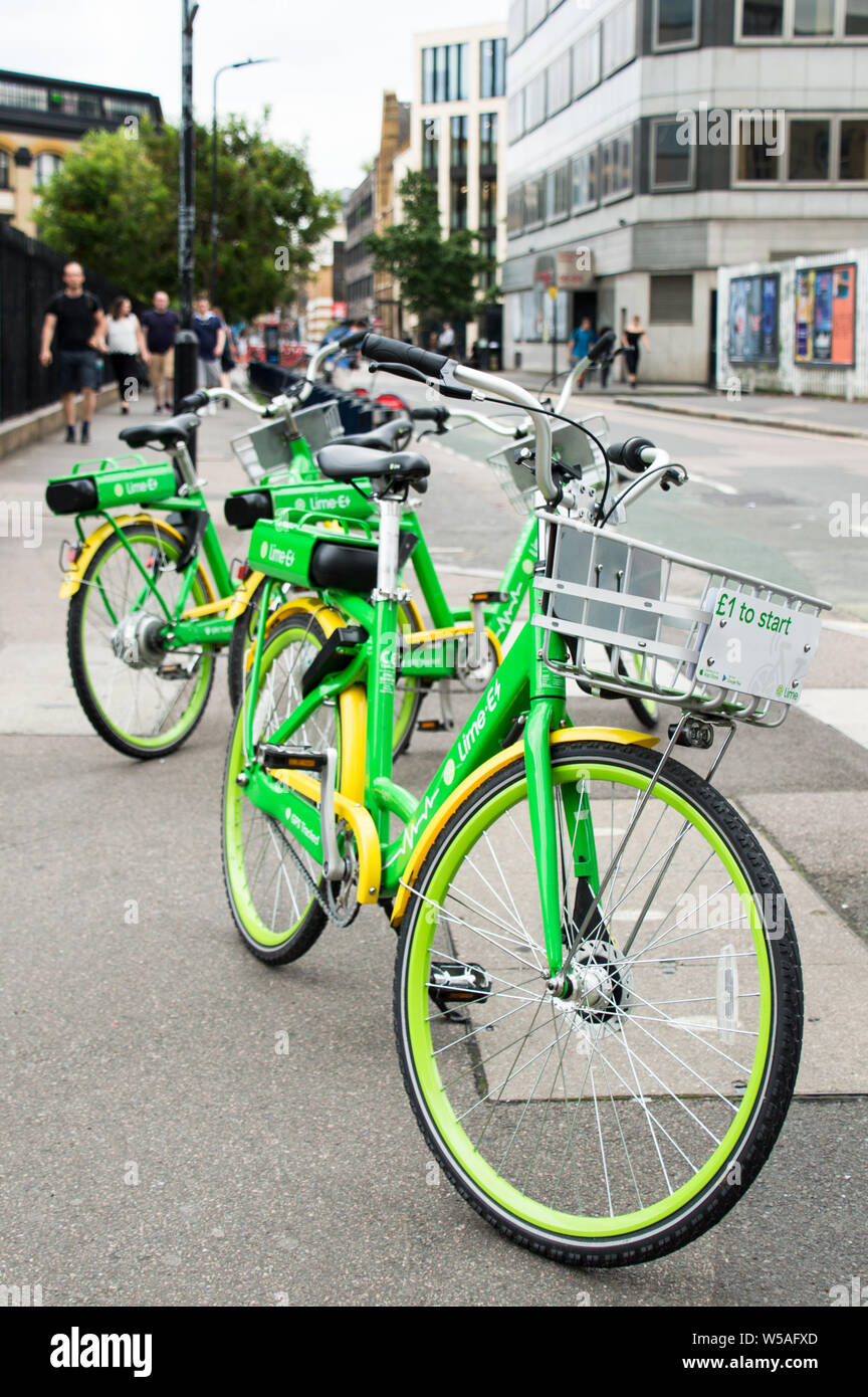 E-Bikes / E-Bikes von Lime-E auf Bürgersteig in London geparkt Stockfoto