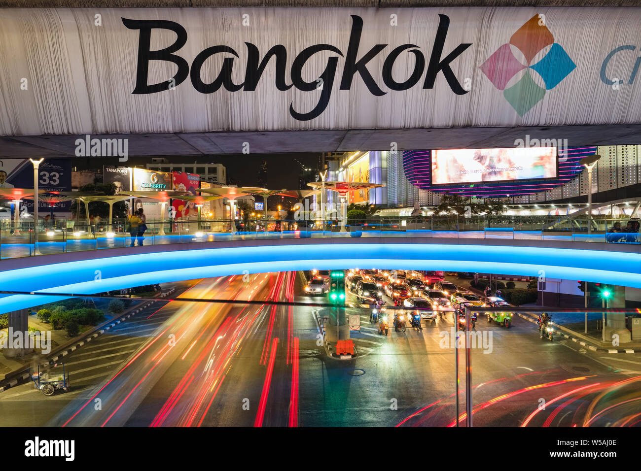 Bangkok, Thailand - 3. März 2019: Bangkok Schild am BTS-u-Brücke und eine belebte Straße in der Nacht im Downtown City Centre Stockfoto