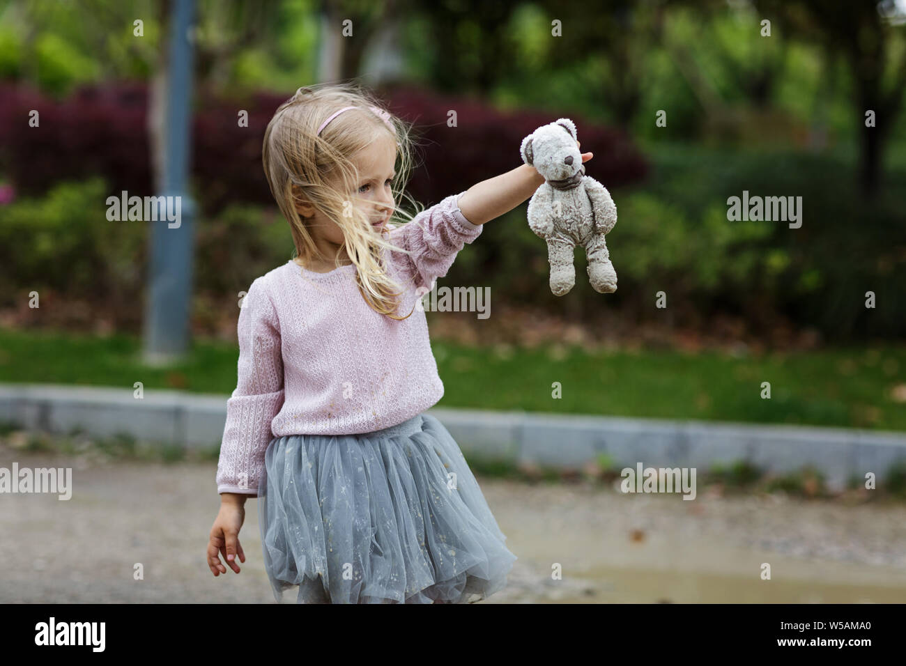 Schönes kleines Mädchen in einem Tutu Rock Holding ein Teddybär im Freien Stockfoto